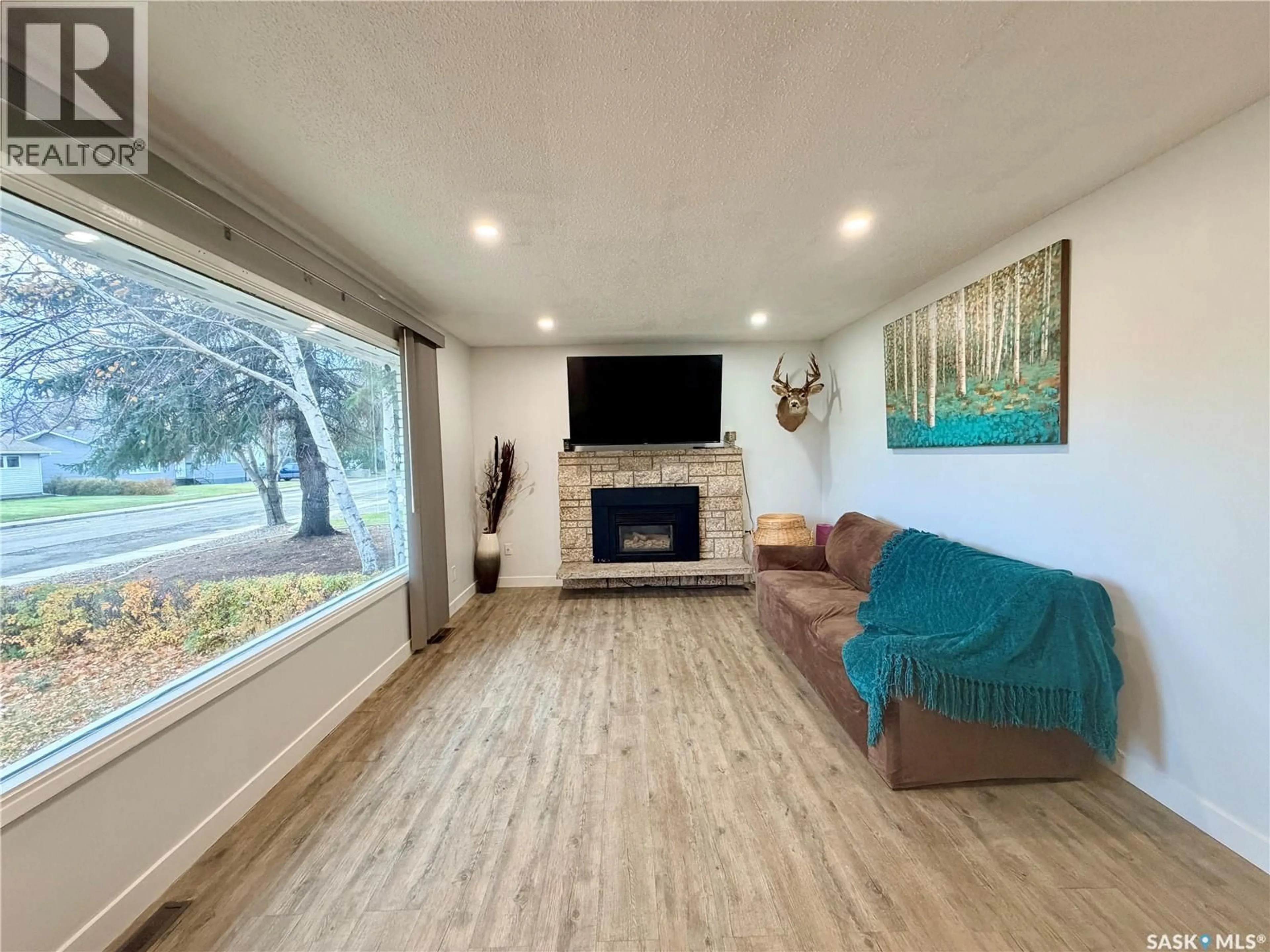 Living room with furniture, wood/laminate floor for 9019 ABBOTT AVENUE, North Battleford Saskatchewan S9A3E8