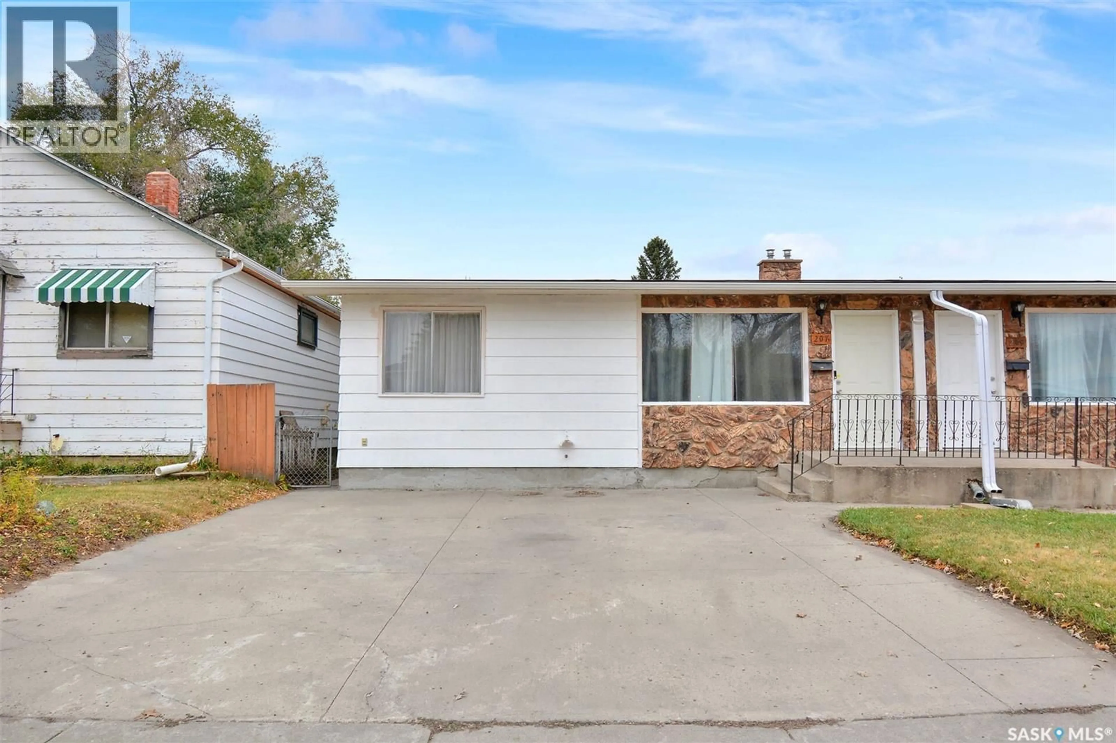 Home with vinyl exterior material, street for 207-209 S AVENUE N, Saskatoon Saskatchewan S7L2Z7
