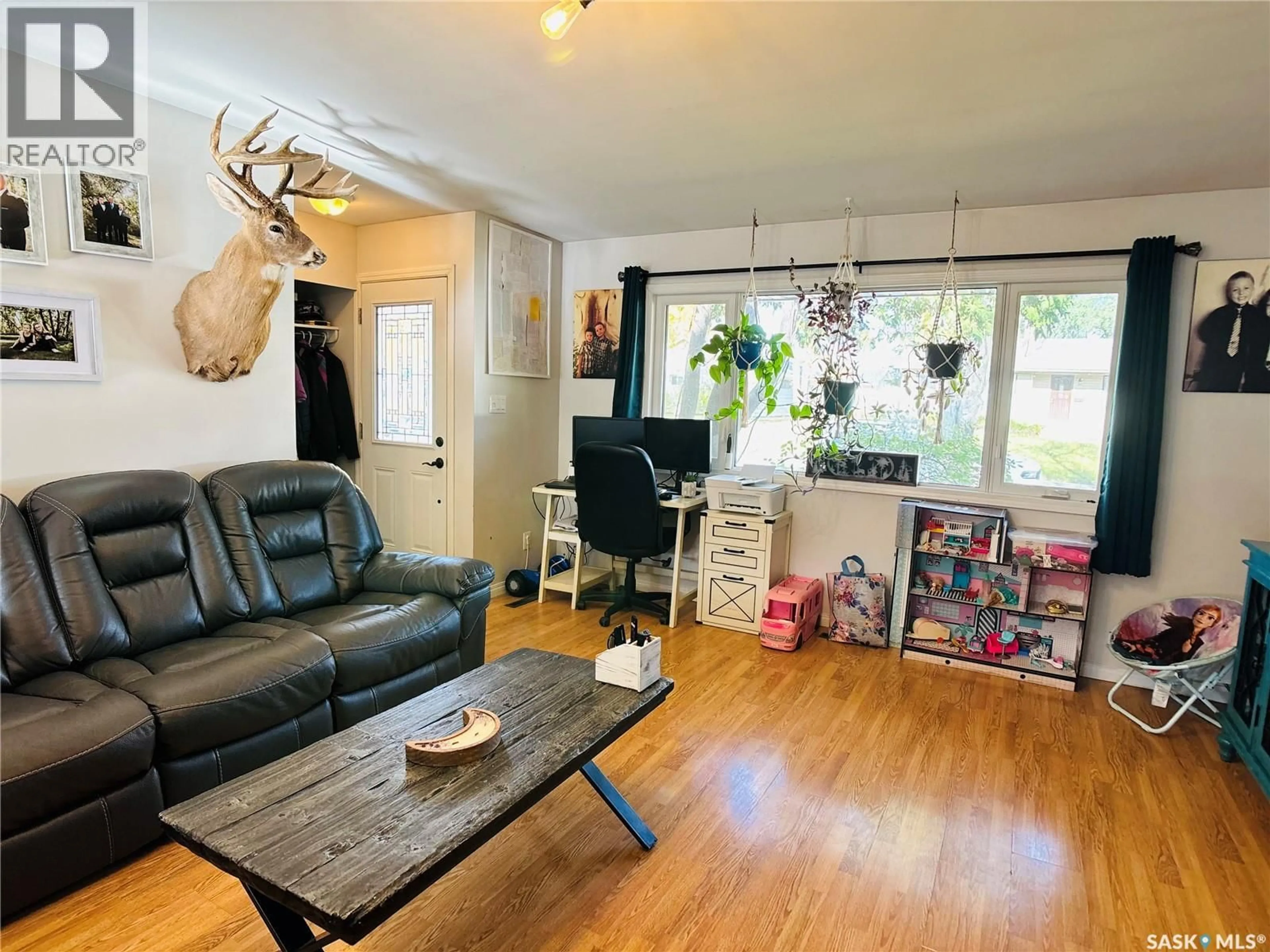 Living room with furniture, wood/laminate floor for 1703 MCCORMICK CRESCENT, Estevan Saskatchewan S4A1W4