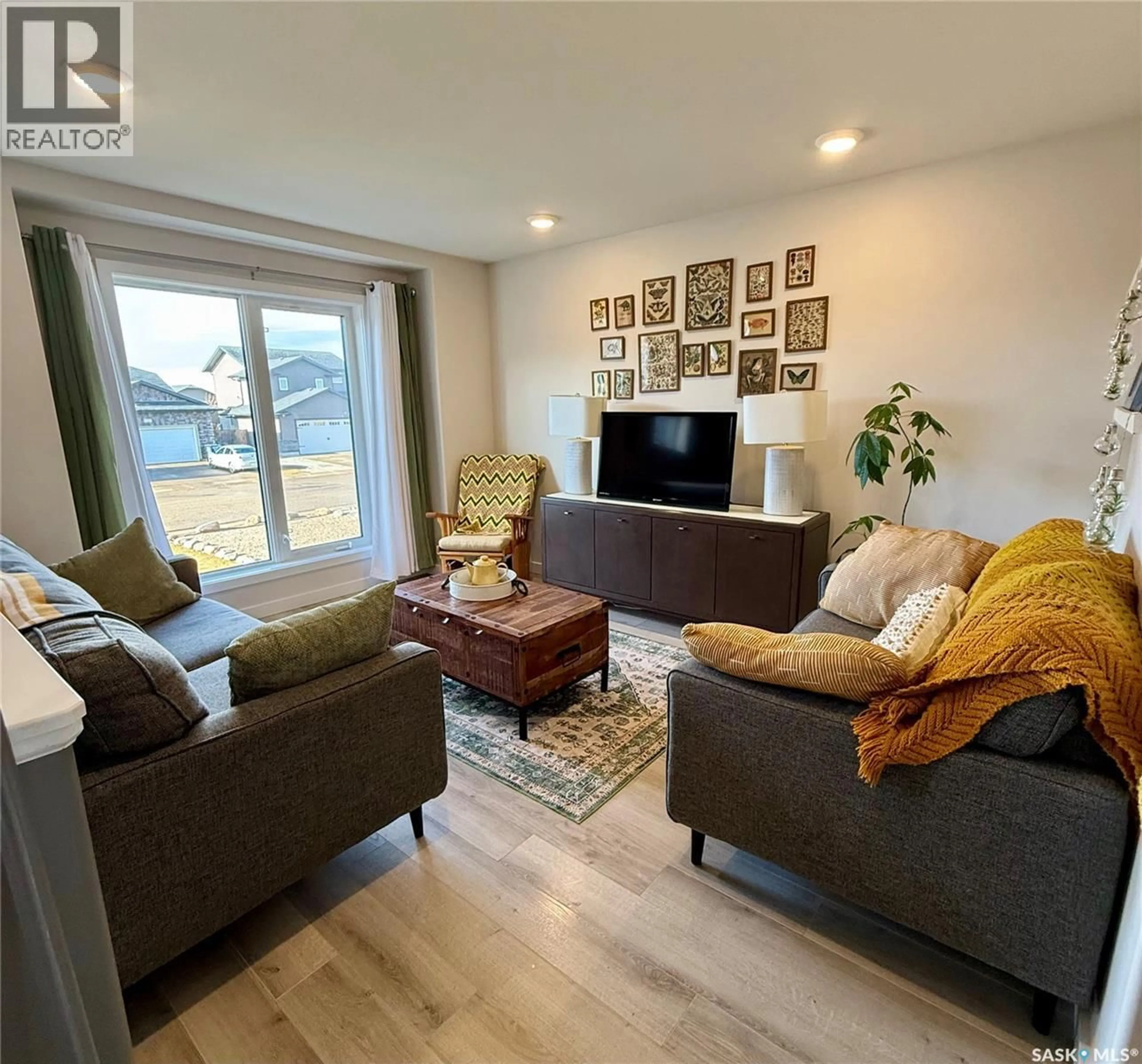 Living room with furniture, wood/laminate floor for 154 FINCH CRESCENT, Langham Saskatchewan S0K2L0