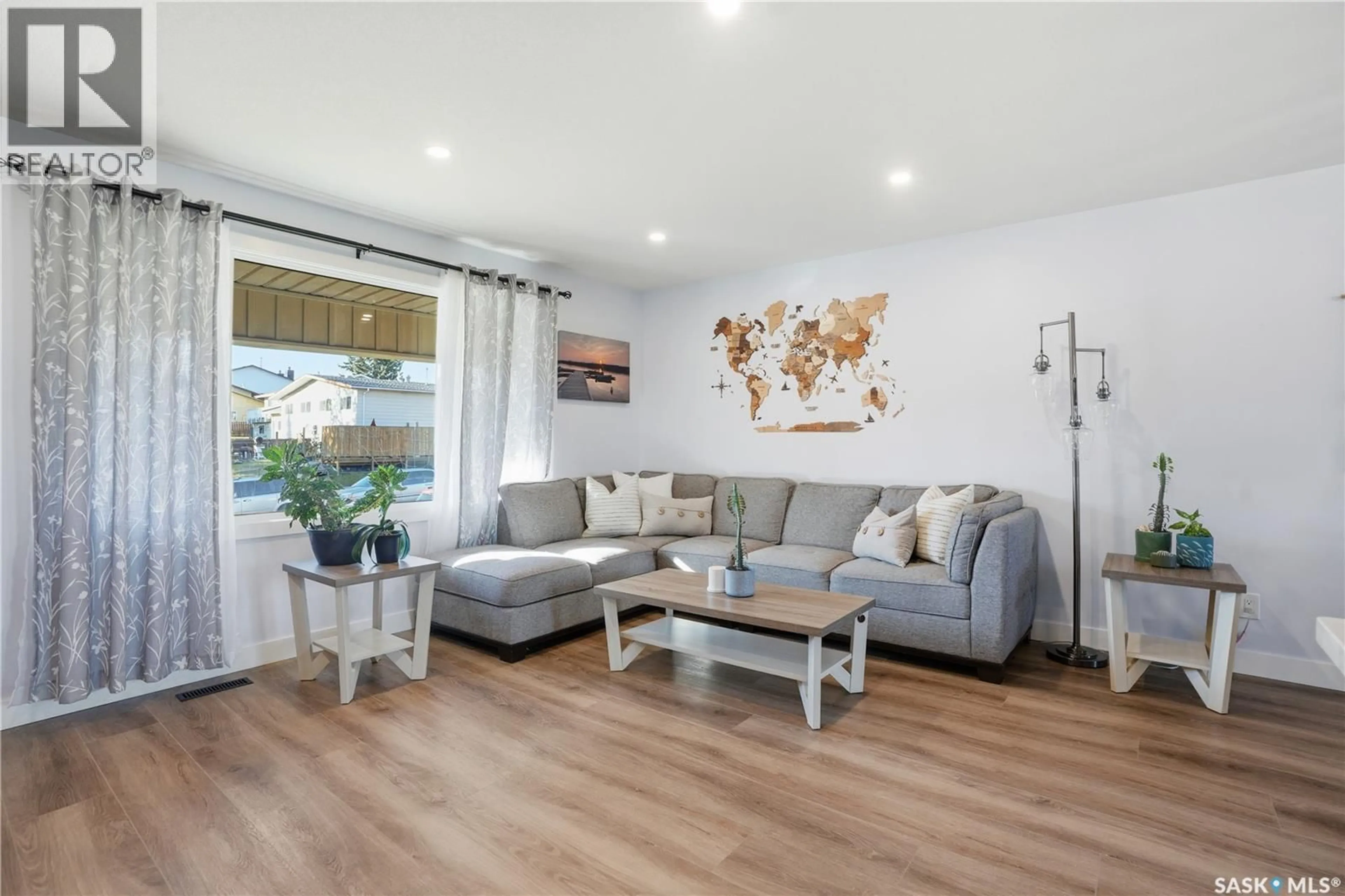 Living room with furniture, wood/laminate floor for 415 WATHAMAN CRESCENT, Saskatoon Saskatchewan S7K4P8