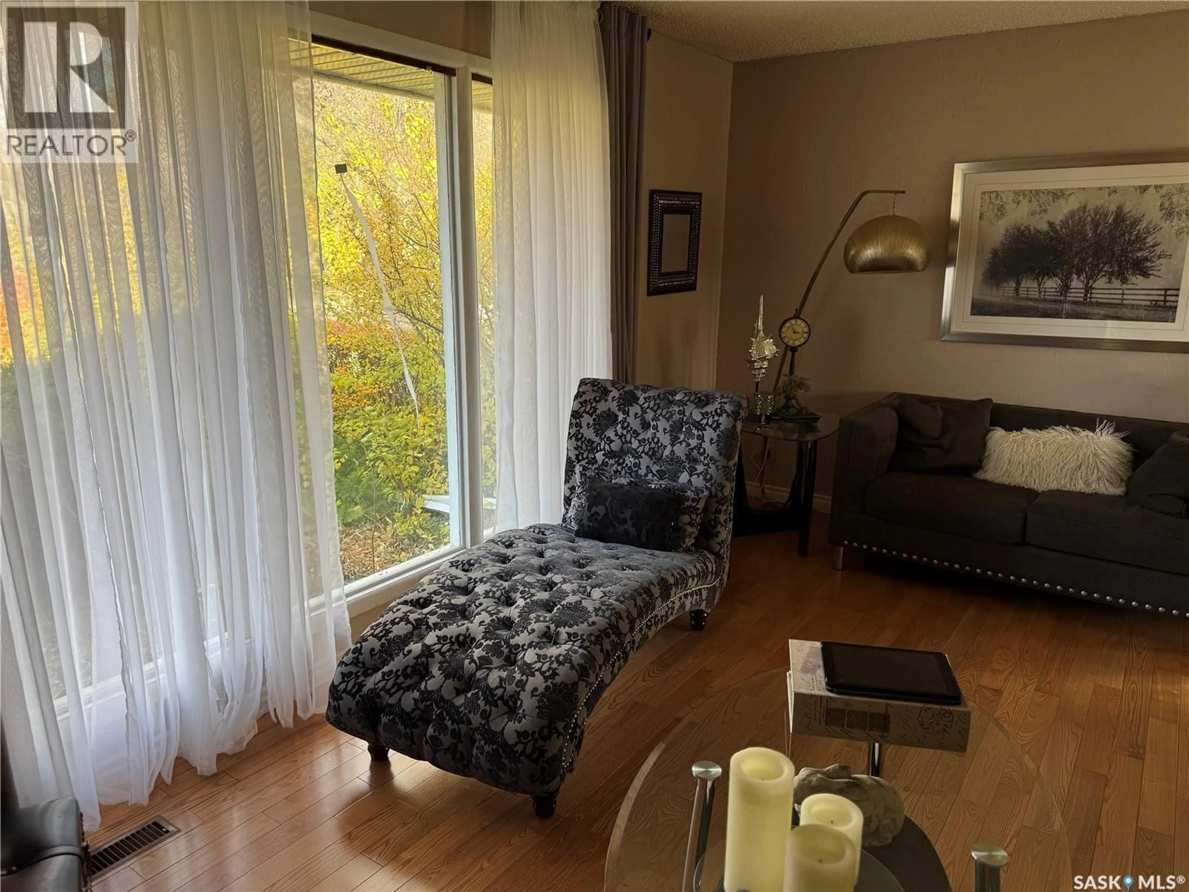 Living room with furniture, wood/laminate floor for 216 ASH DRIVE, Weyburn Saskatchewan S4H0S2