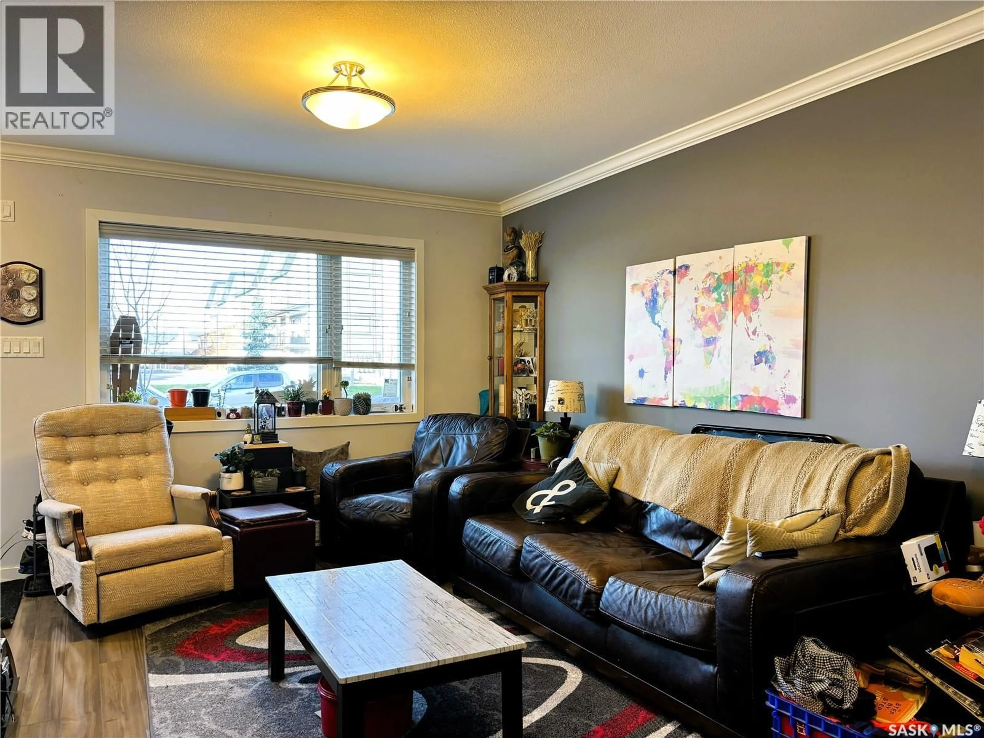 Living room with furniture, wood/laminate floor for 270 250 AKHTAR BEND, Saskatoon Saskatchewan S7W0W4