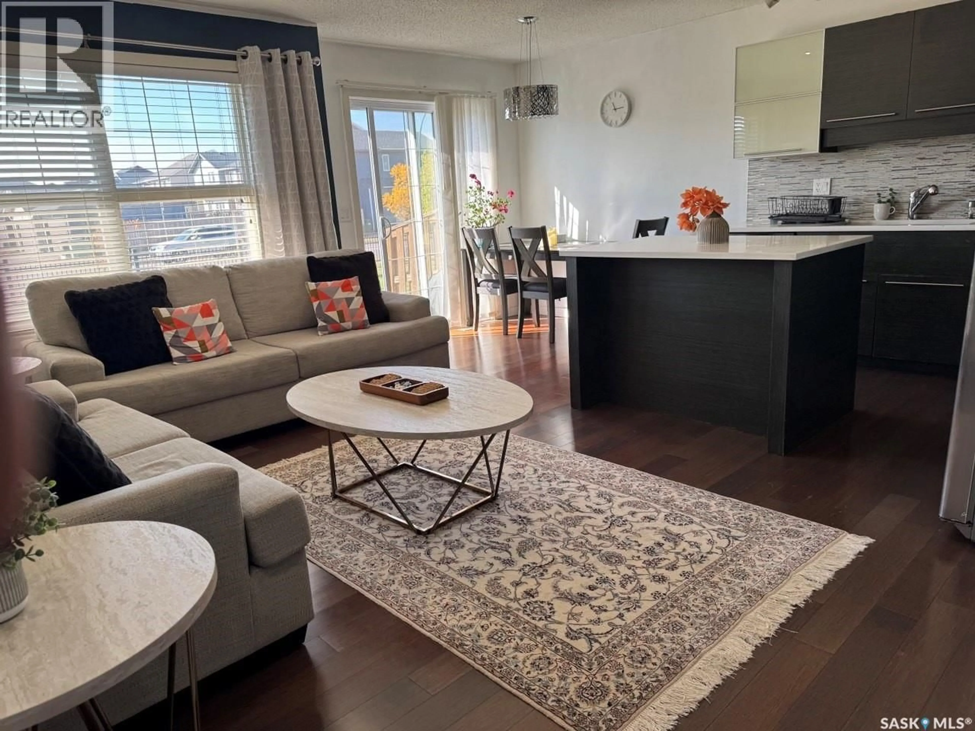 Living room with furniture, wood/laminate floor for 106 - 410 LEDINGHAM WAY, Saskatoon Saskatchewan S7V0C4