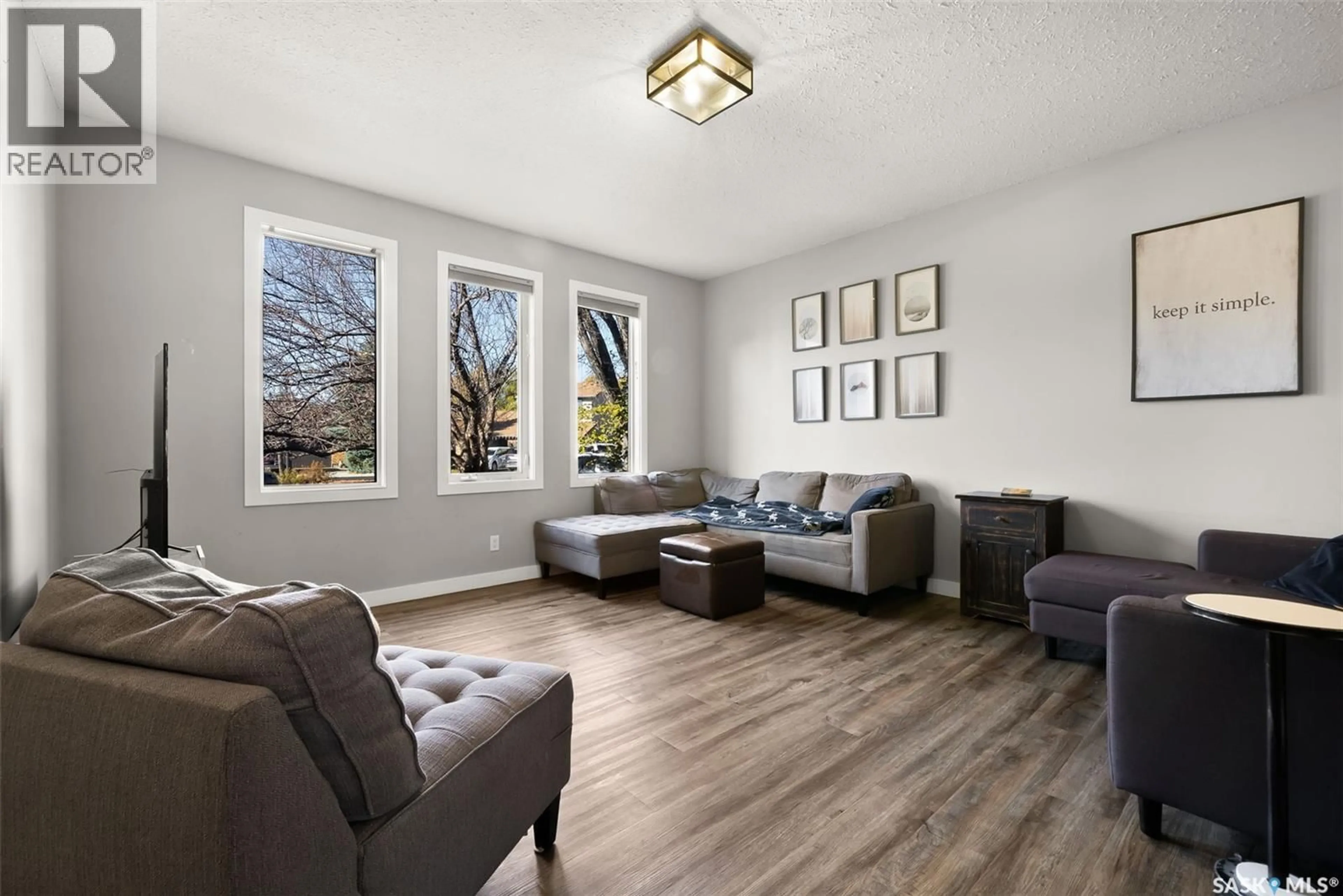 Living room with furniture, wood/laminate floor for 2218 BALDWIN BAY, Regina Saskatchewan S4V1H2