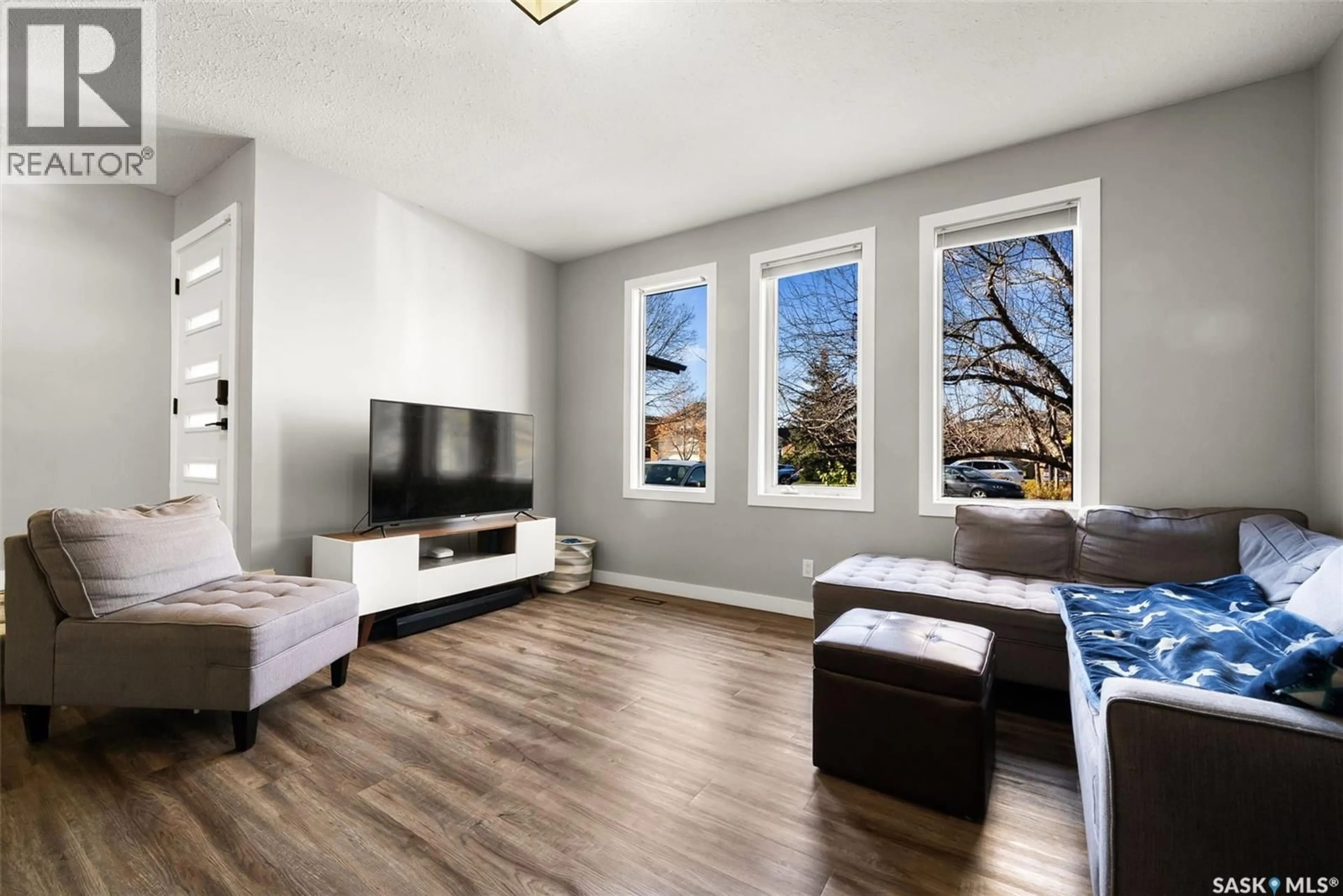 Living room with furniture, wood/laminate floor for 2218 BALDWIN BAY, Regina Saskatchewan S4V1H2