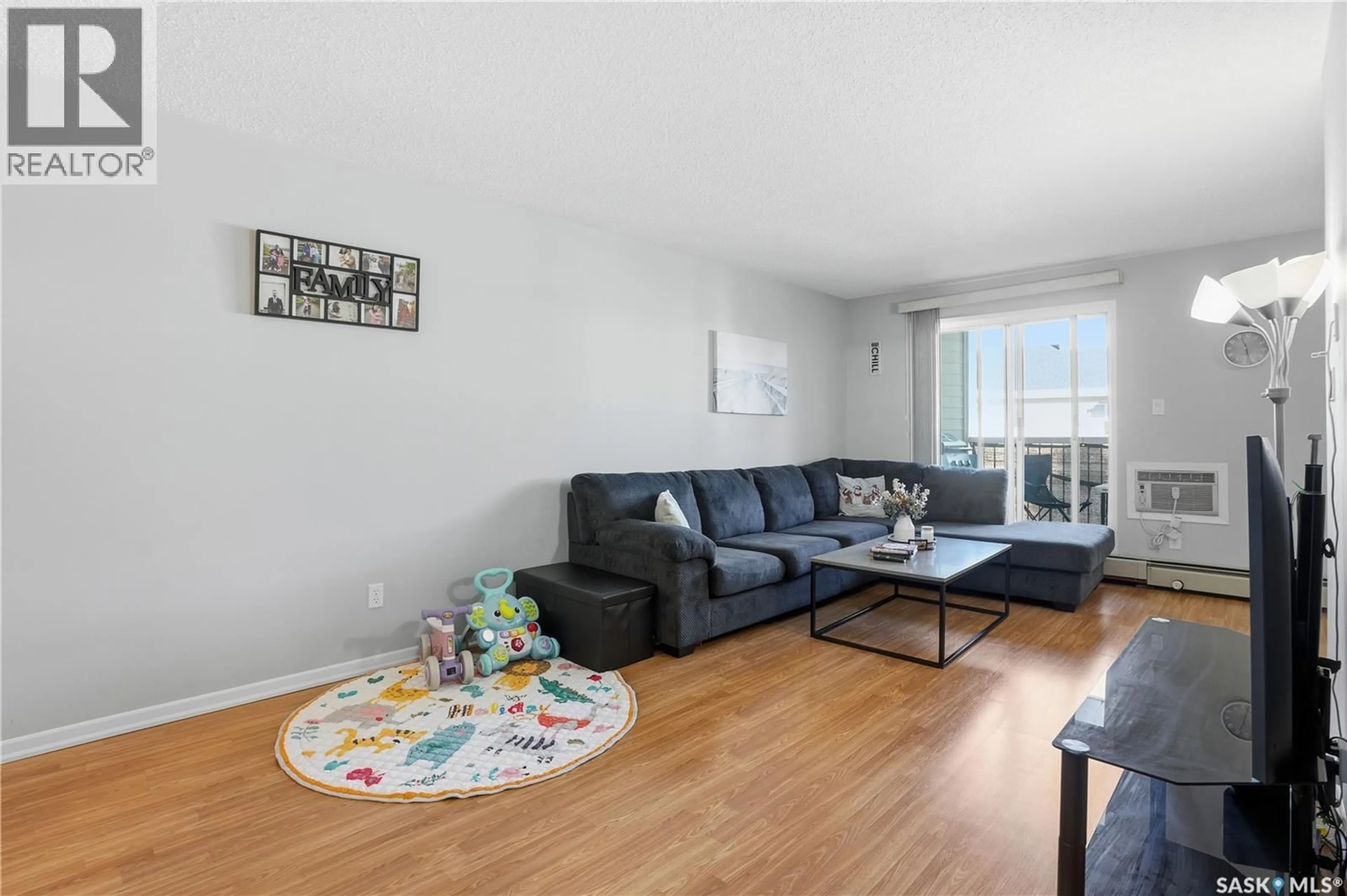Living room with furniture, wood/laminate floor for 309A - 301 CREE CRESCENT, Saskatoon Saskatchewan S7K7Y3