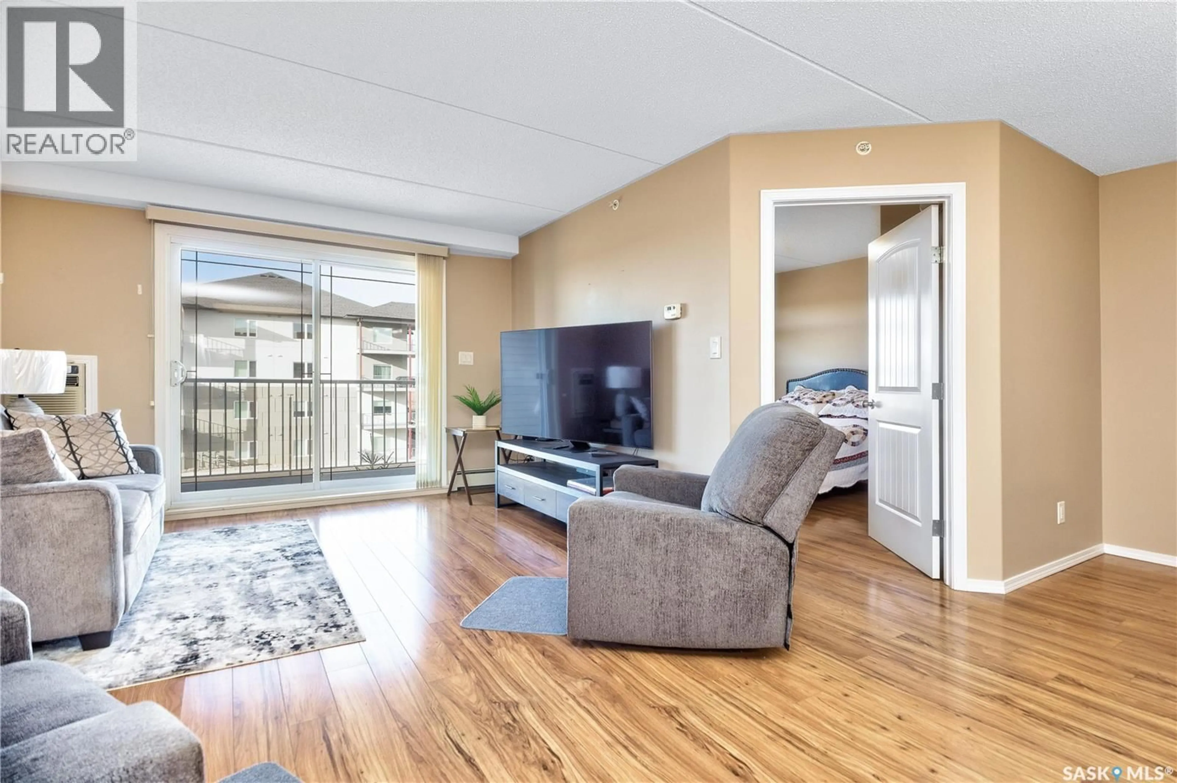 Living room with furniture, wood/laminate floor for 305 - 2781 WOODBRIDGE DRIVE, Prince Albert Saskatchewan S6V3Z9