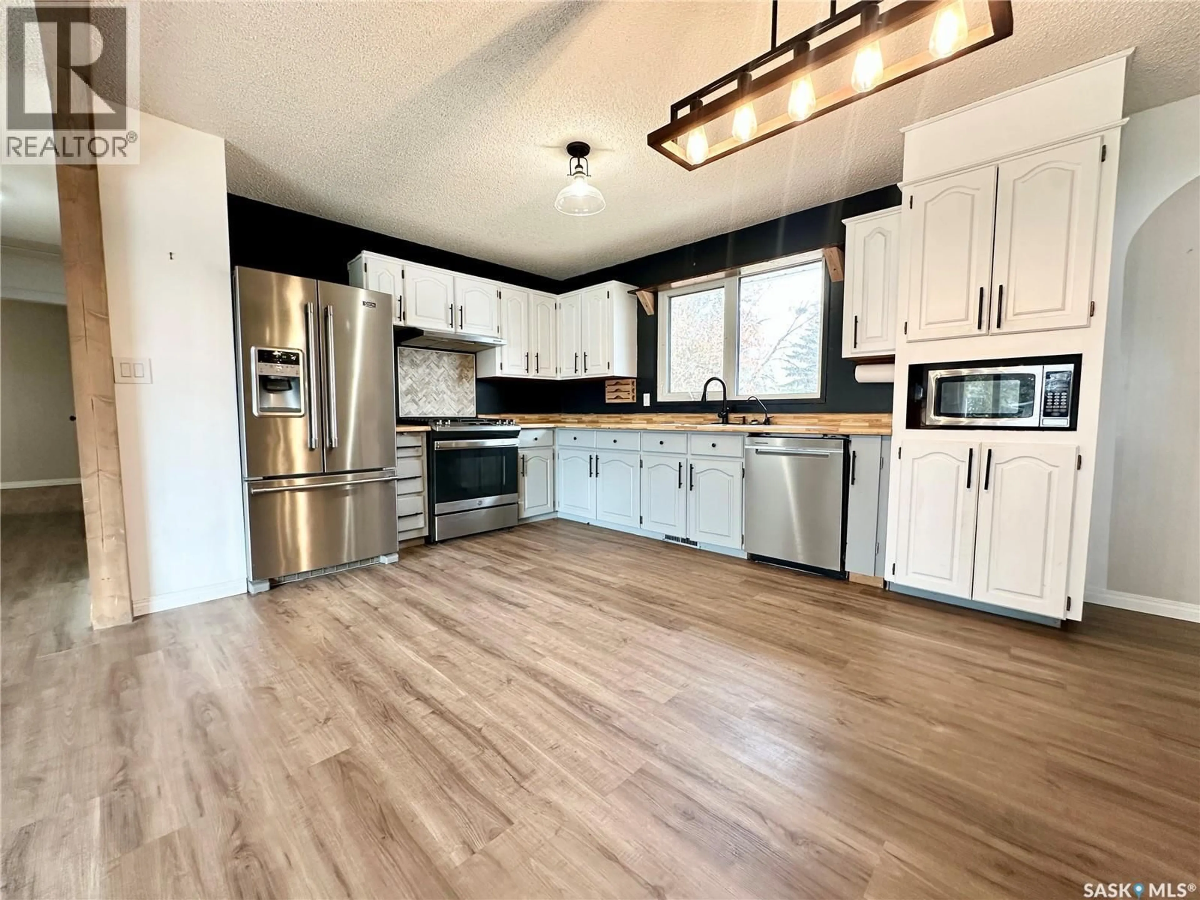Open concept kitchen, wood/laminate floor for 224 17TH STREET, Weyburn Saskatchewan S4H2P2