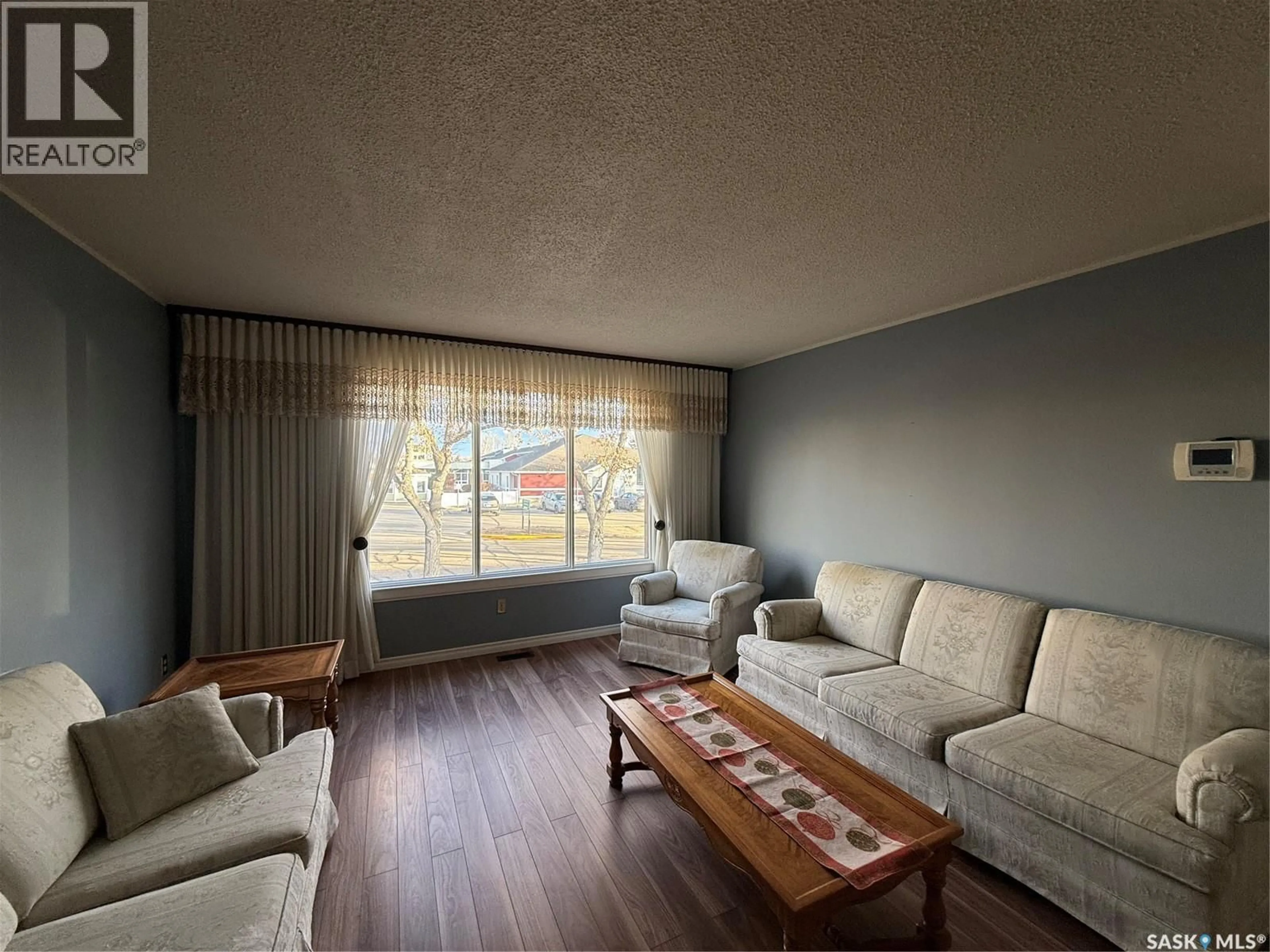 Living room with furniture, wood/laminate floor for 516 6TH AVENUE, Assiniboia Saskatchewan S0H0B0