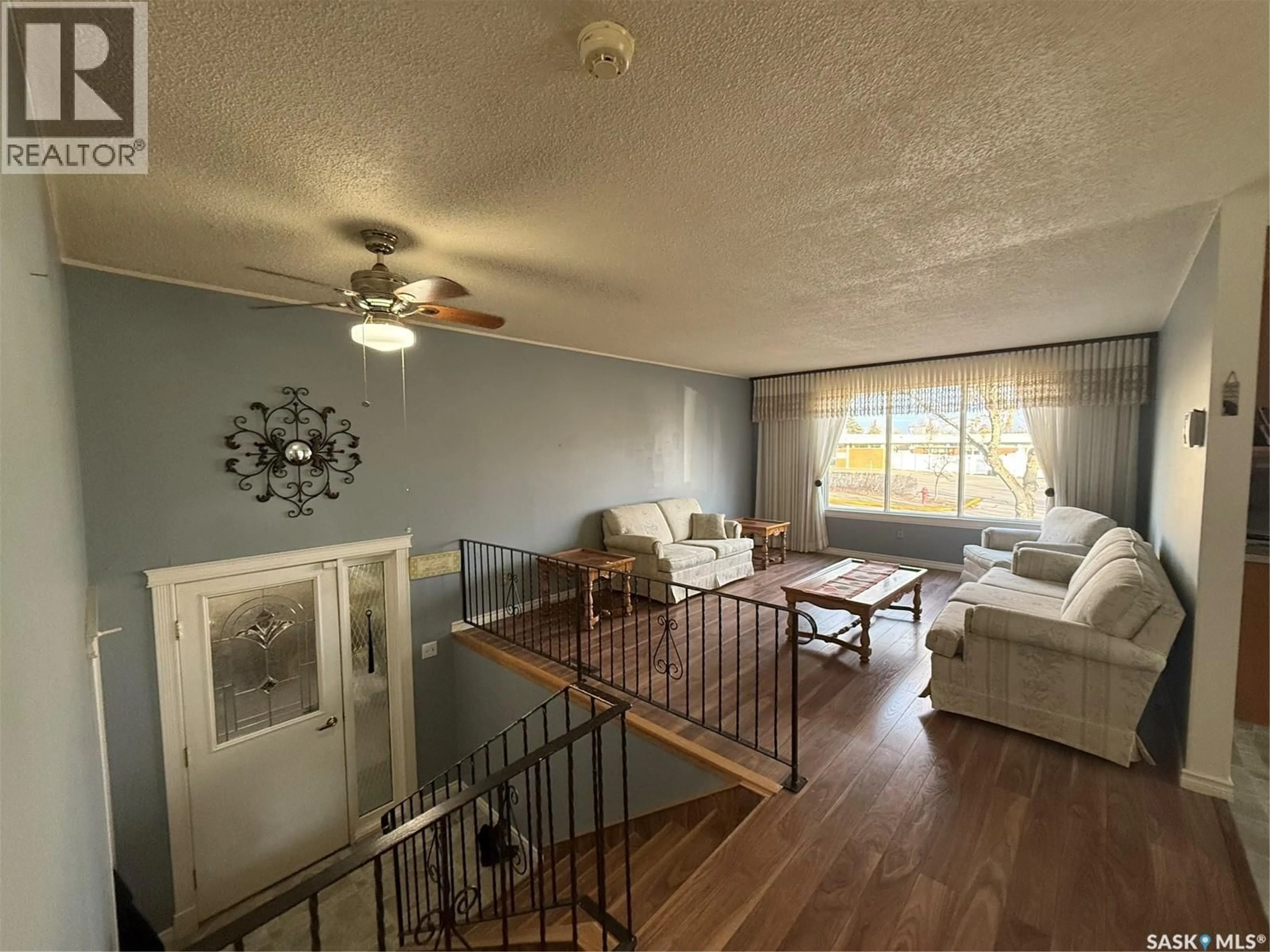 Living room with furniture, wood/laminate floor for 516 6TH AVENUE, Assiniboia Saskatchewan S0H0B0