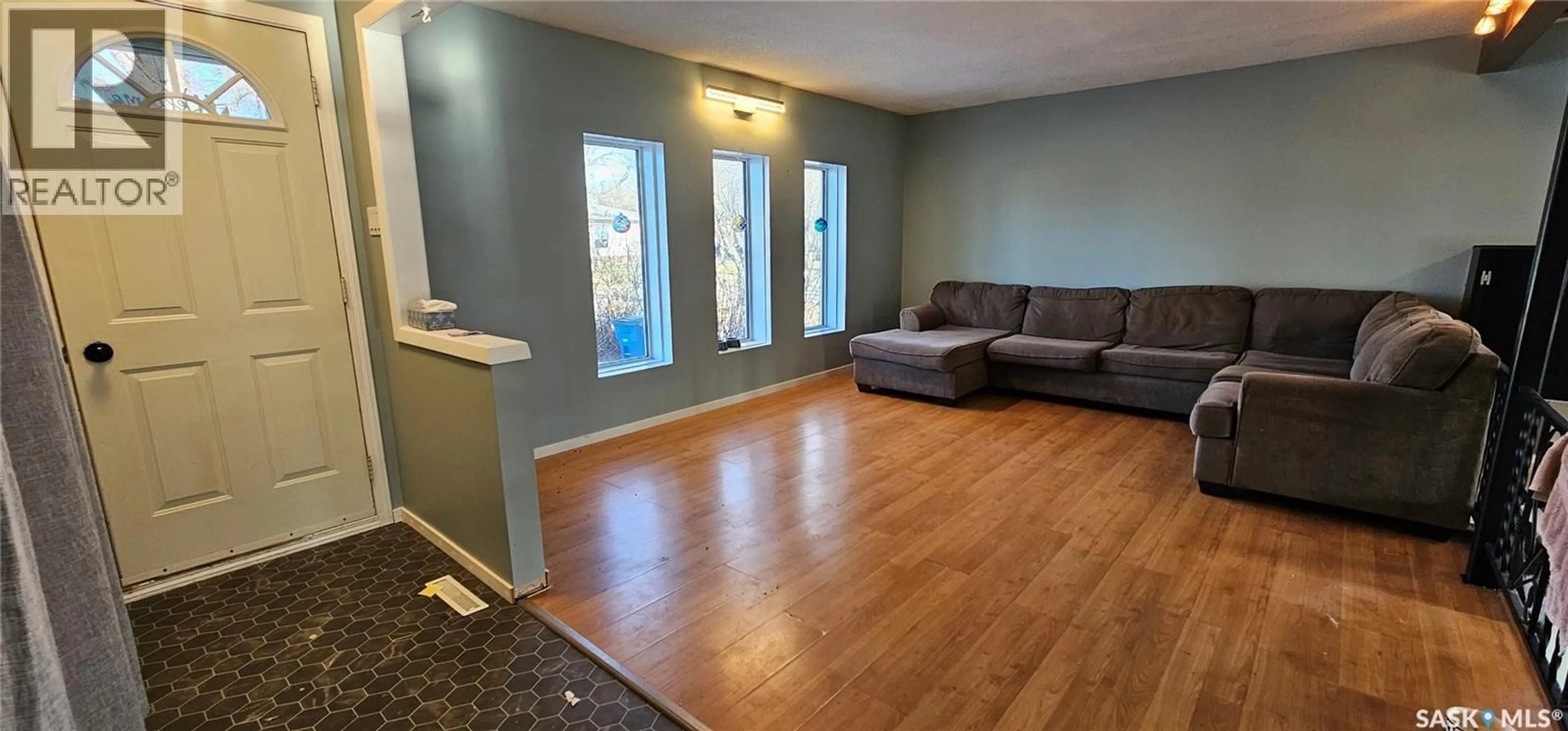 Living room with furniture, wood/laminate floor for 1010 104TH AVENUE, Tisdale Saskatchewan S0E1T0
