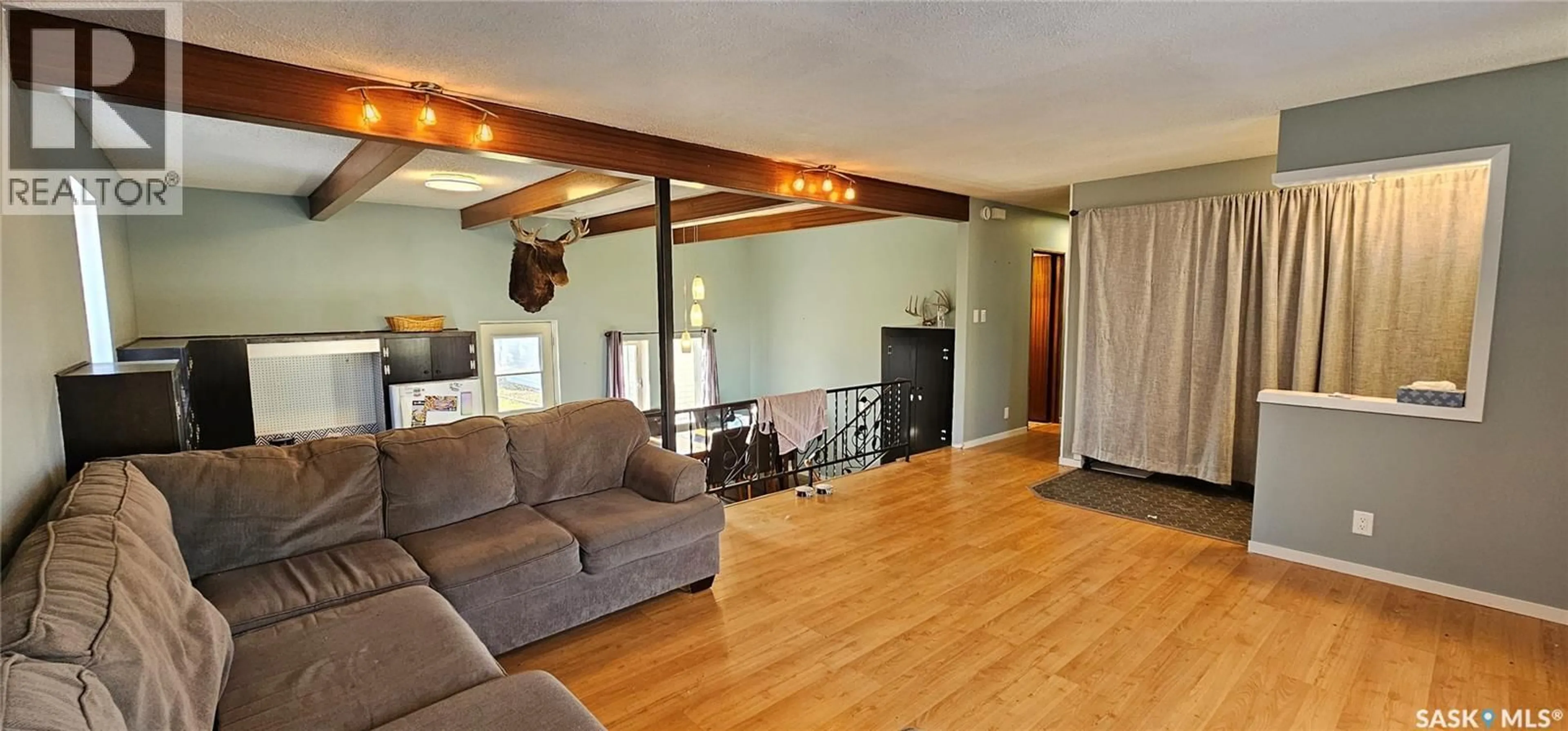 Living room with furniture, wood/laminate floor for 1010 104TH AVENUE, Tisdale Saskatchewan S0E1T0