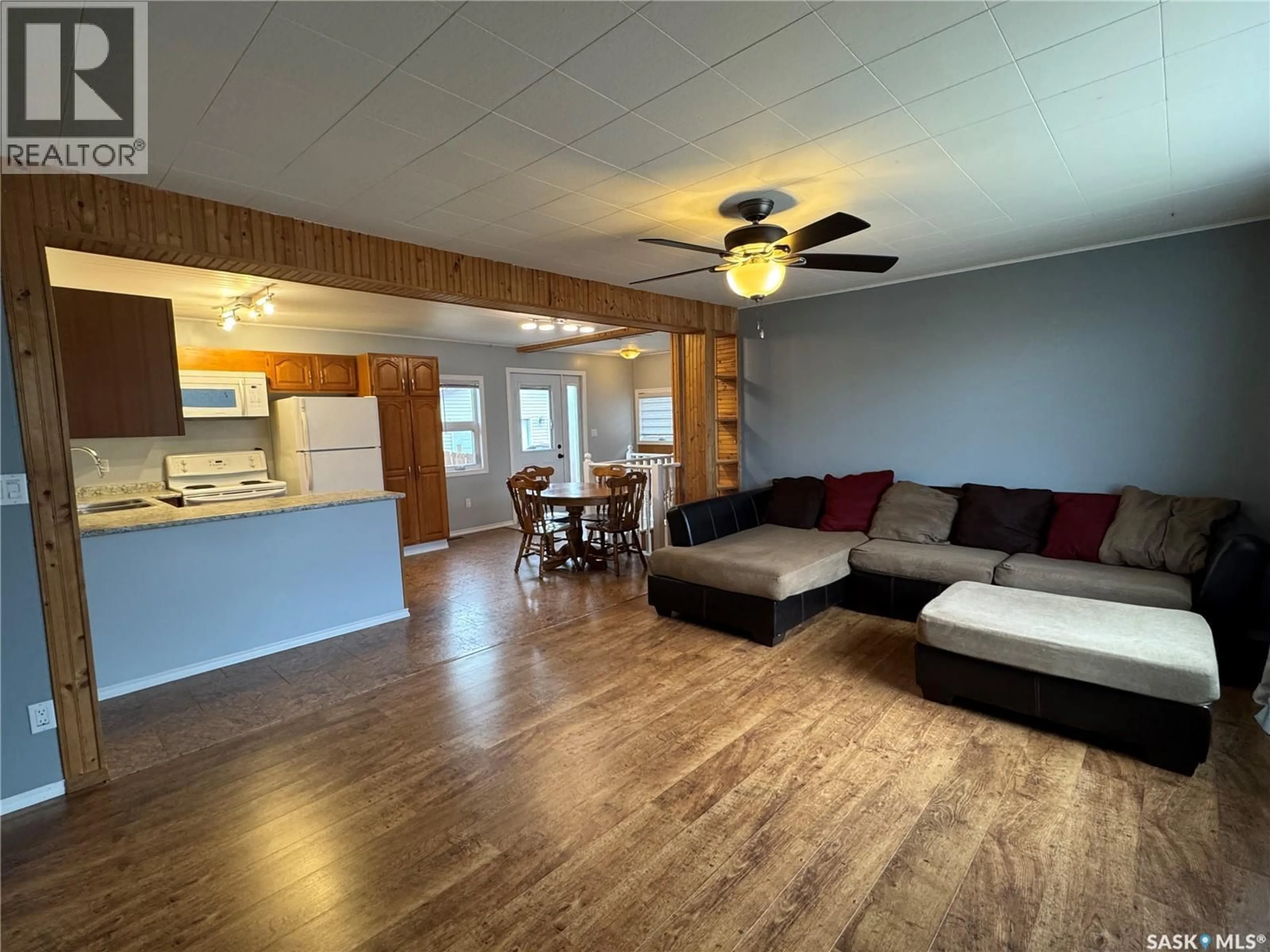 Living room with furniture, wood/laminate floor for 413 2ND AVENUE, Biggar Saskatchewan S0K0M0
