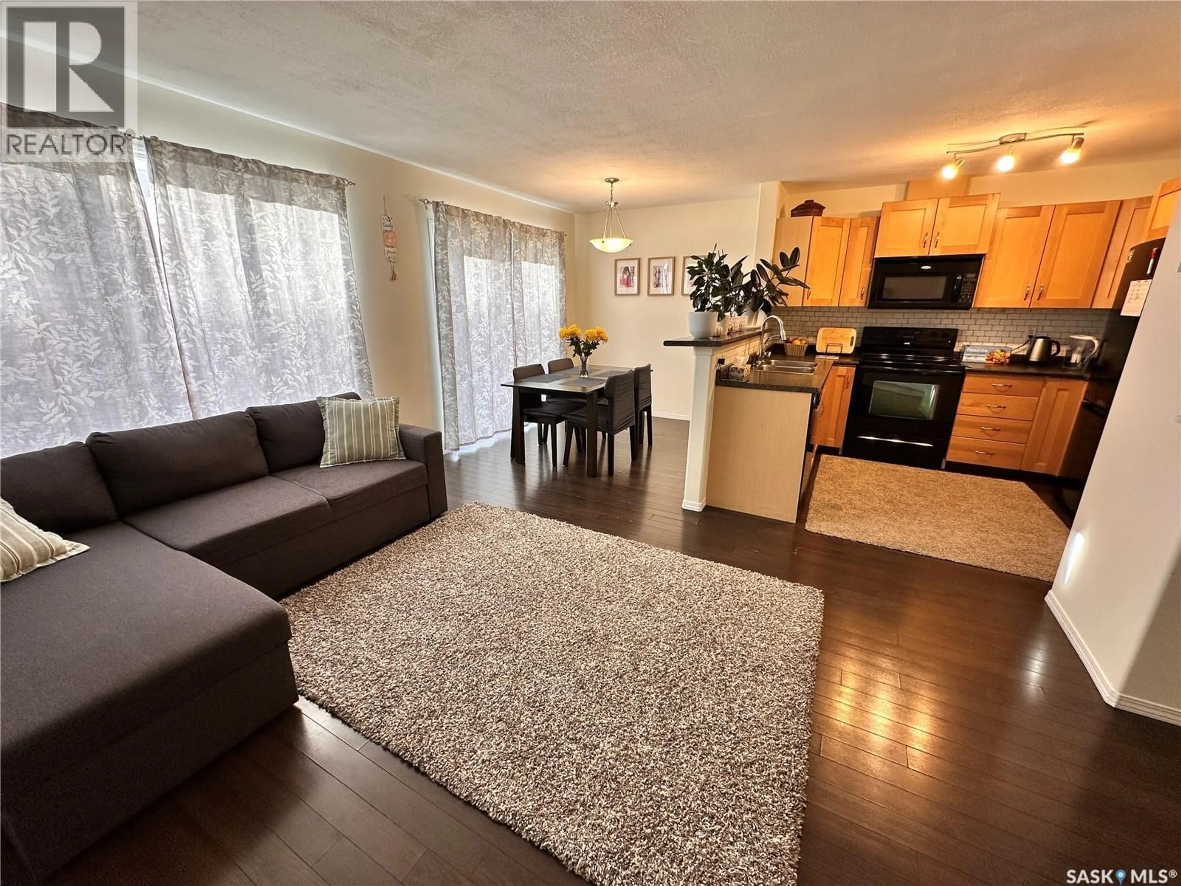 Living room with furniture, wood/laminate floor for 19 2751 WINDSOR PARK ROAD, Regina Saskatchewan S4V1H1