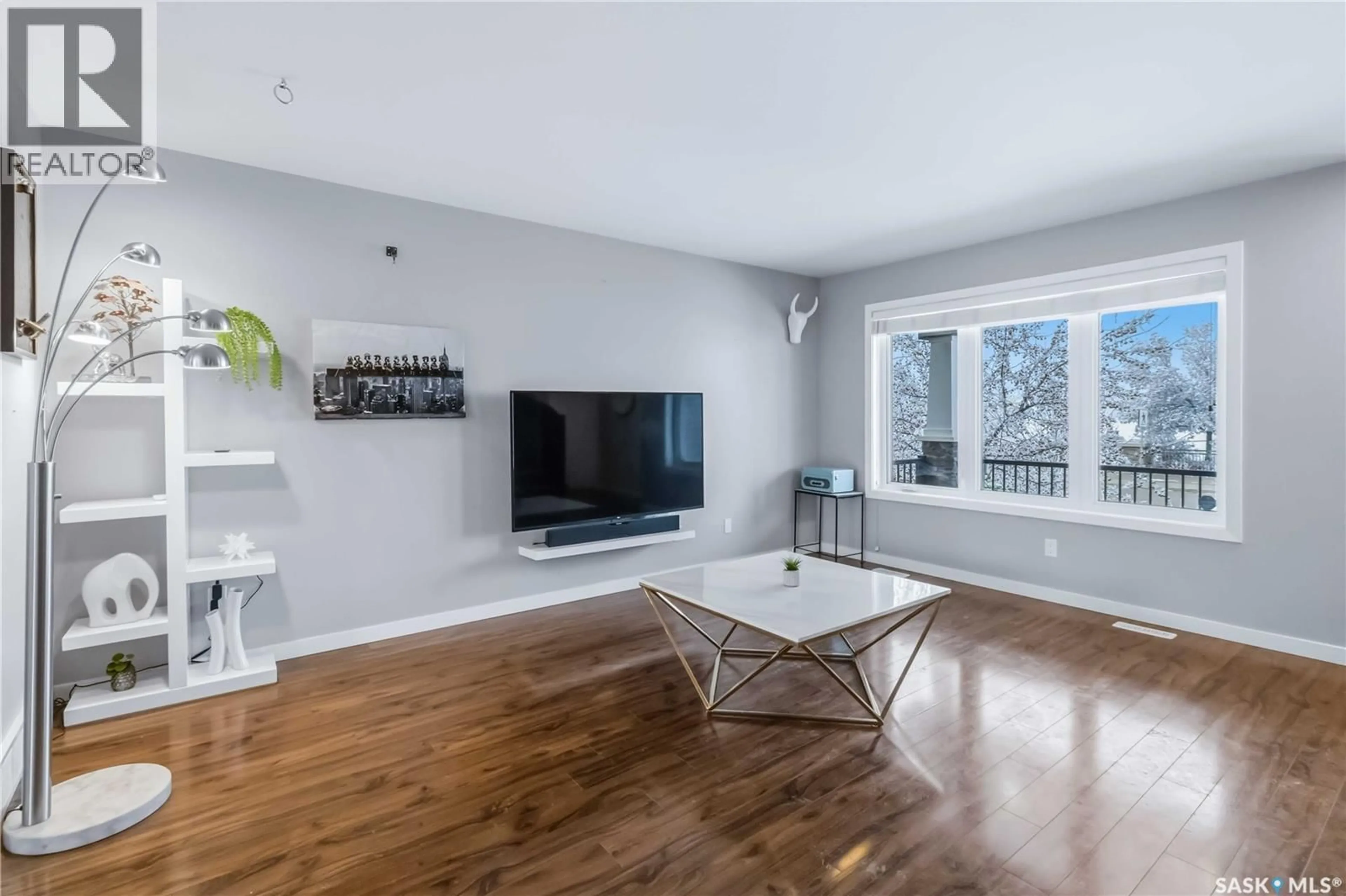 Living room with furniture, wood/laminate floor for 706 STONEBRIDGE COMMON, Saskatoon Saskatchewan S7T0M9