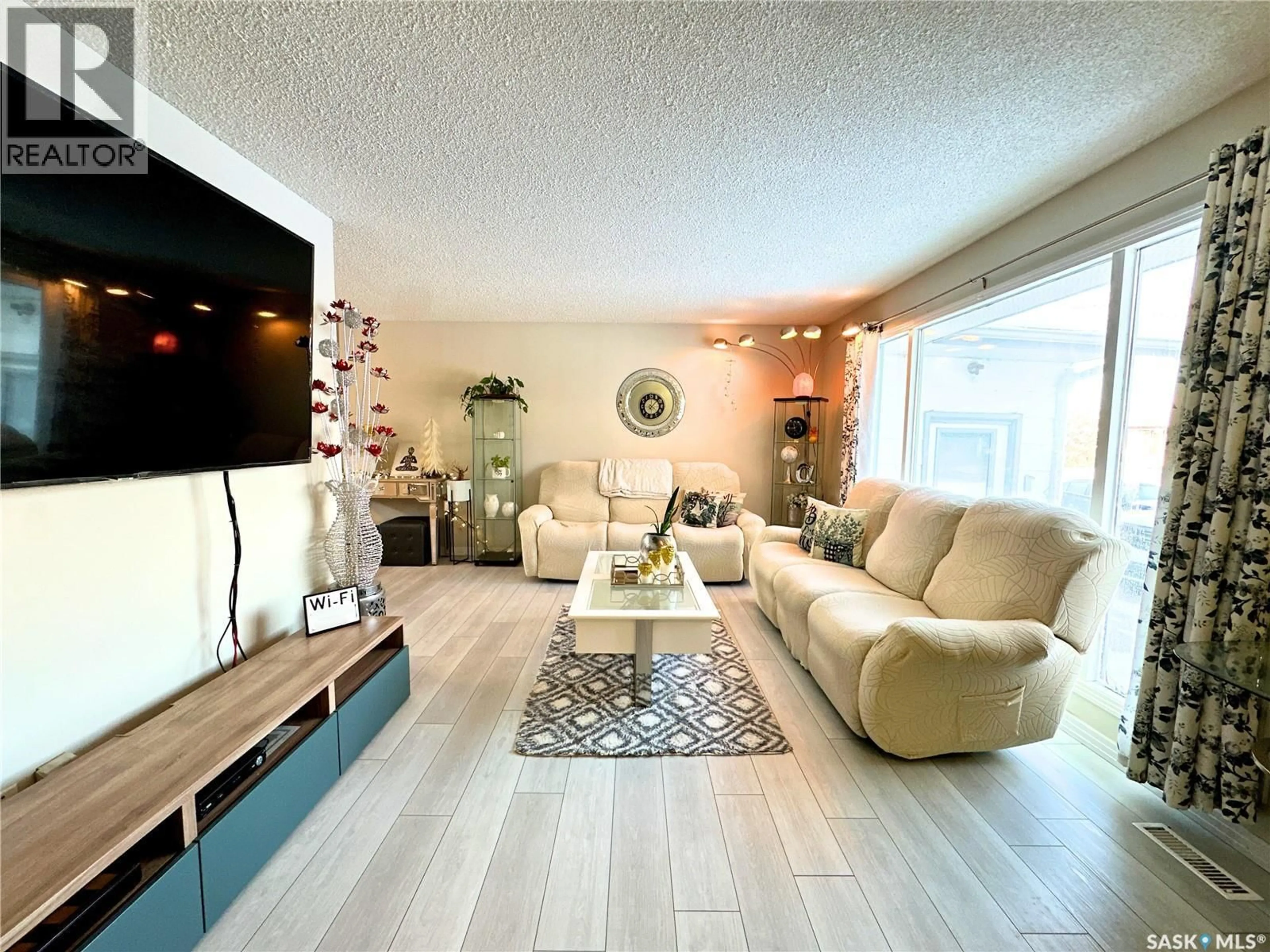 Living room with furniture, wood/laminate floor for 1015 WYLLIE CRESCENT, Prince Albert Saskatchewan S6V6L7