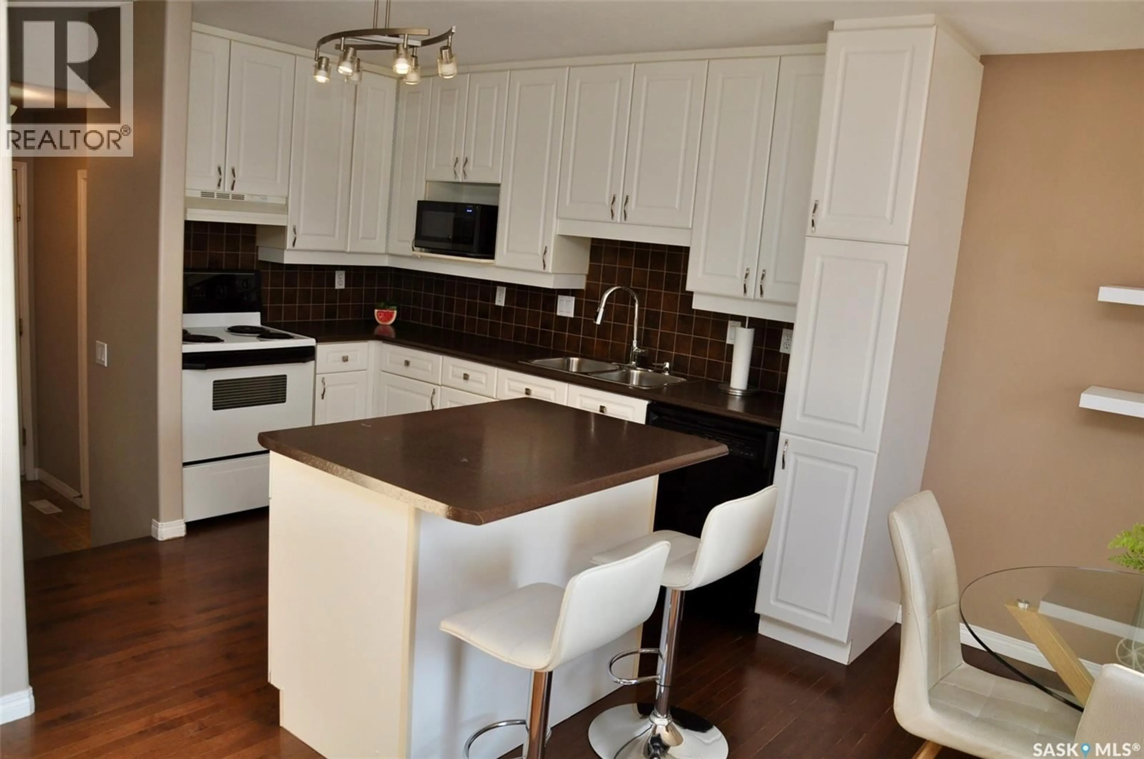 Open concept kitchen, wood/laminate floor for 104 515 MCWILLIE AVENUE, Saskatoon Saskatchewan S7S1K8