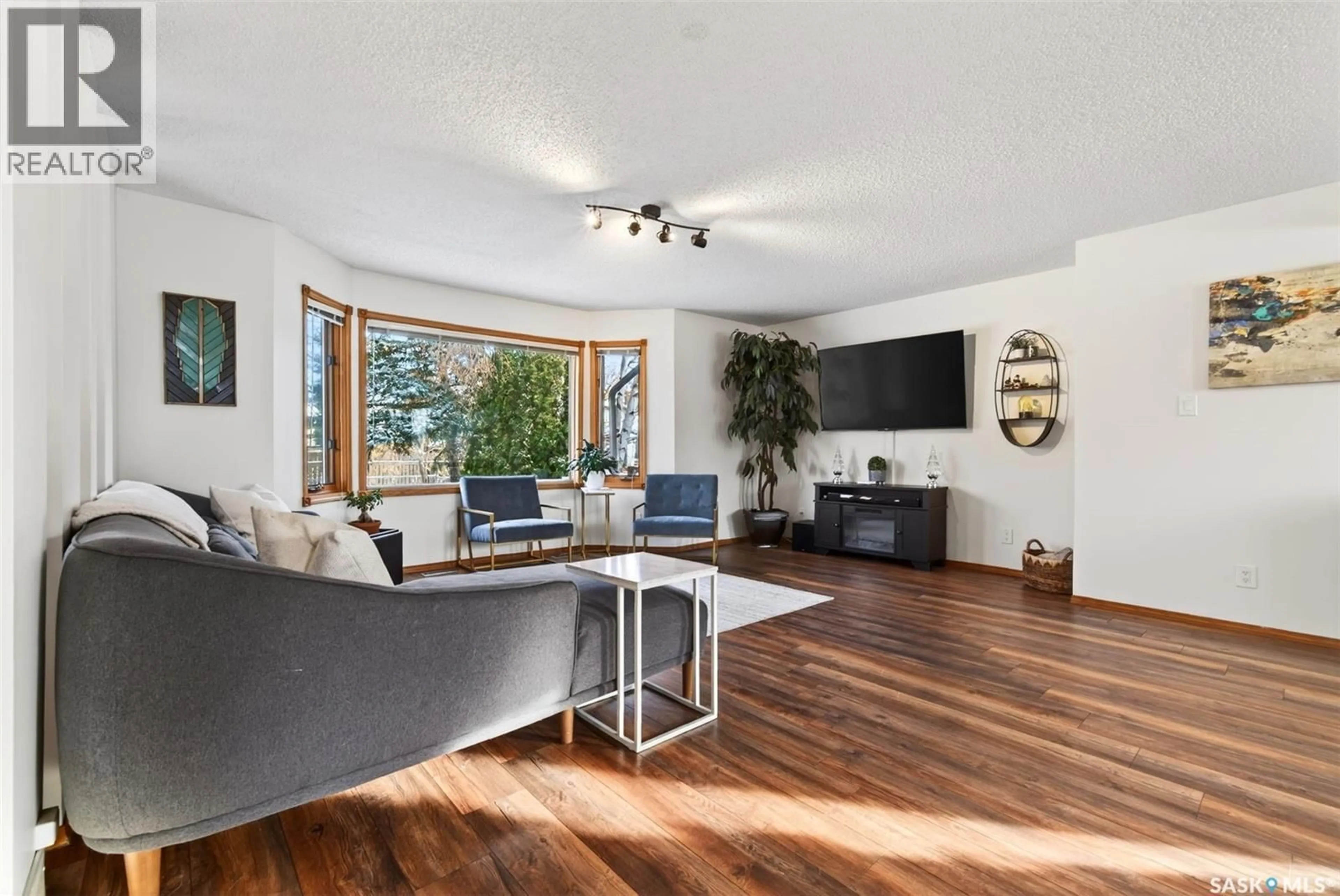 Living room with furniture, wood/laminate floor for 2010 ASSINIBOINE AVENUE, Regina Saskatchewan S4V2E2