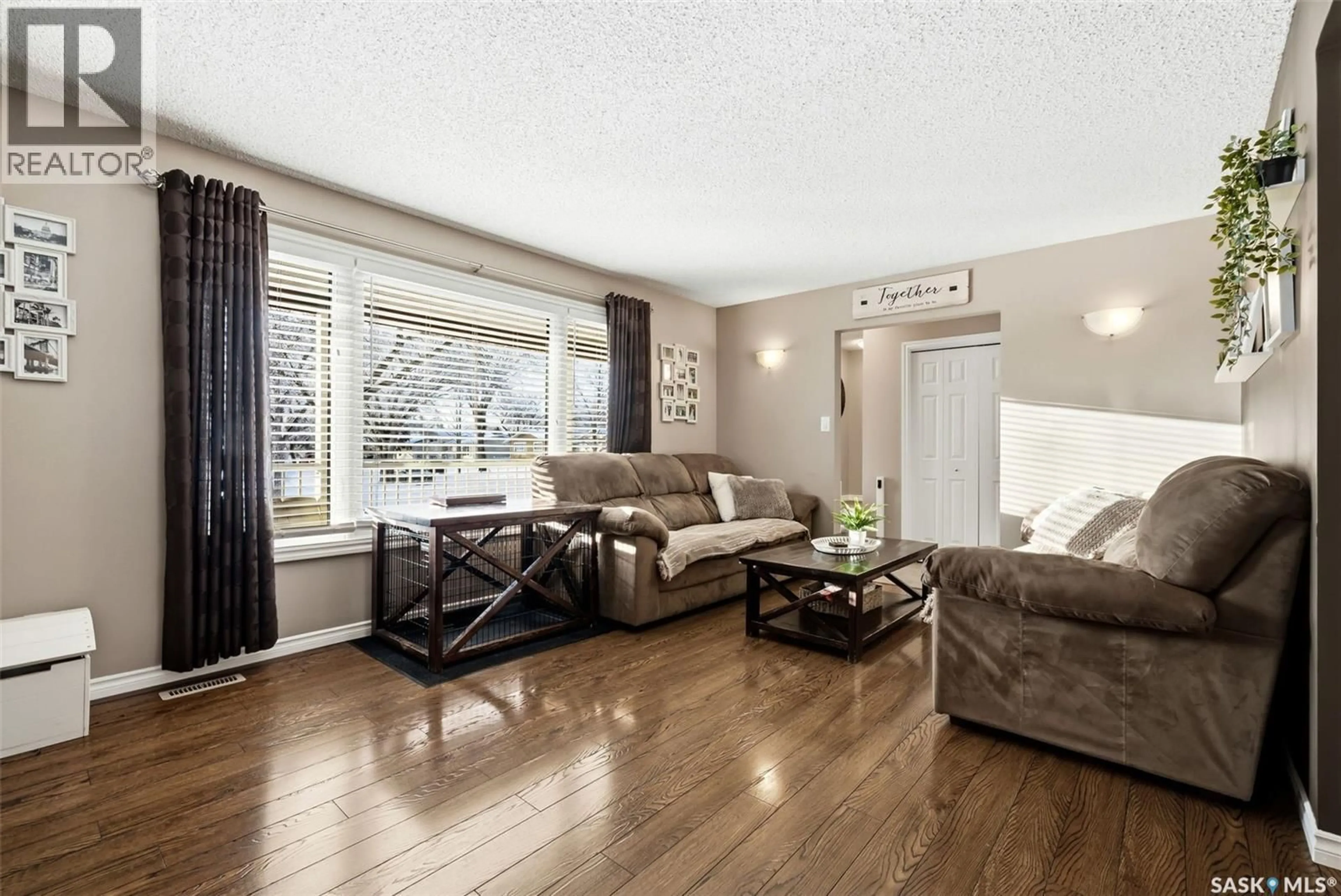 Living room with furniture, wood/laminate floor for 63 CHAMP CRESCENT, Regina Saskatchewan S4R5B5