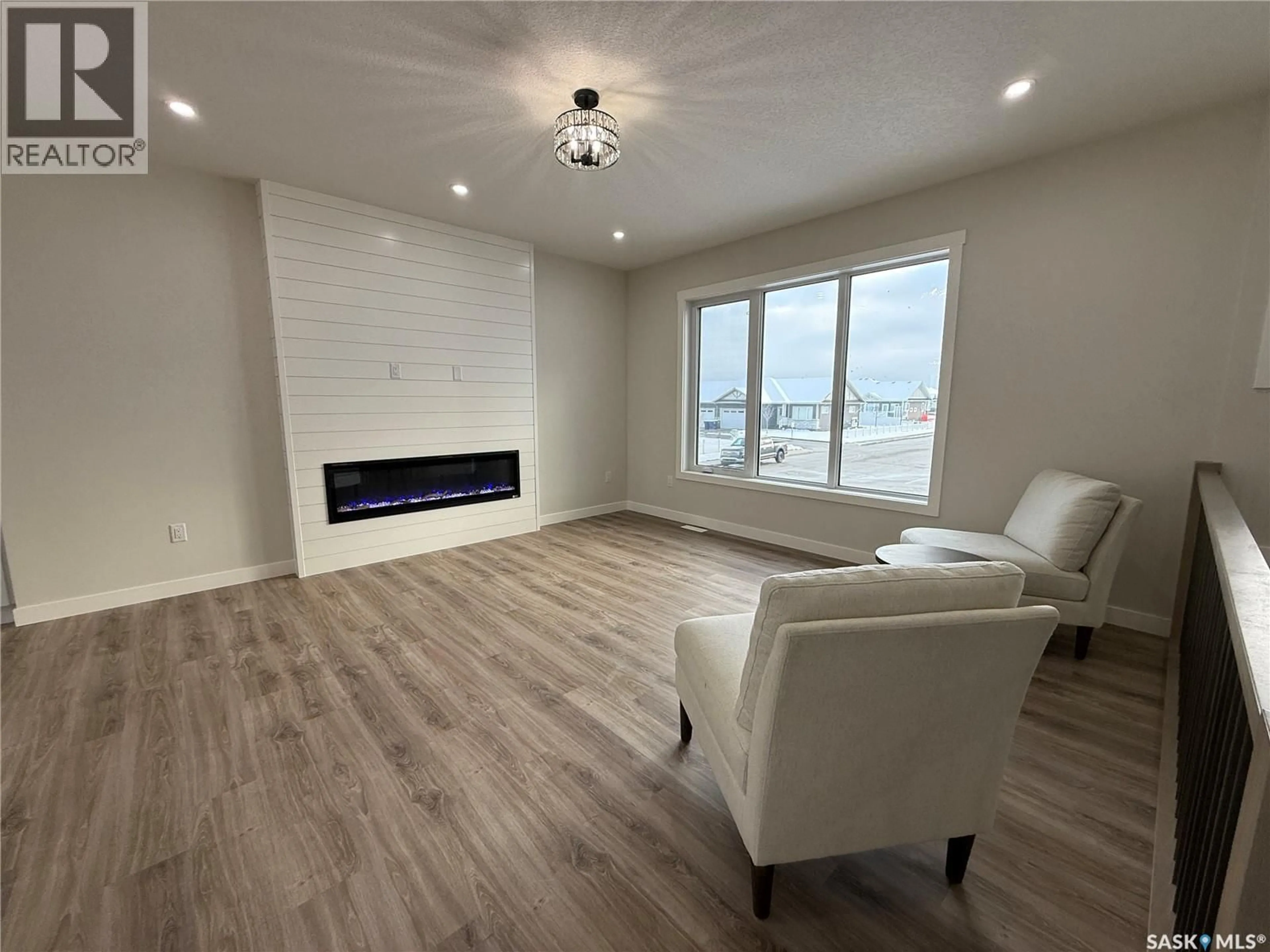 Living room with furniture, wood/laminate floor for 806 BALLESTEROS CRESCENT, Warman Saskatchewan S0K4S4