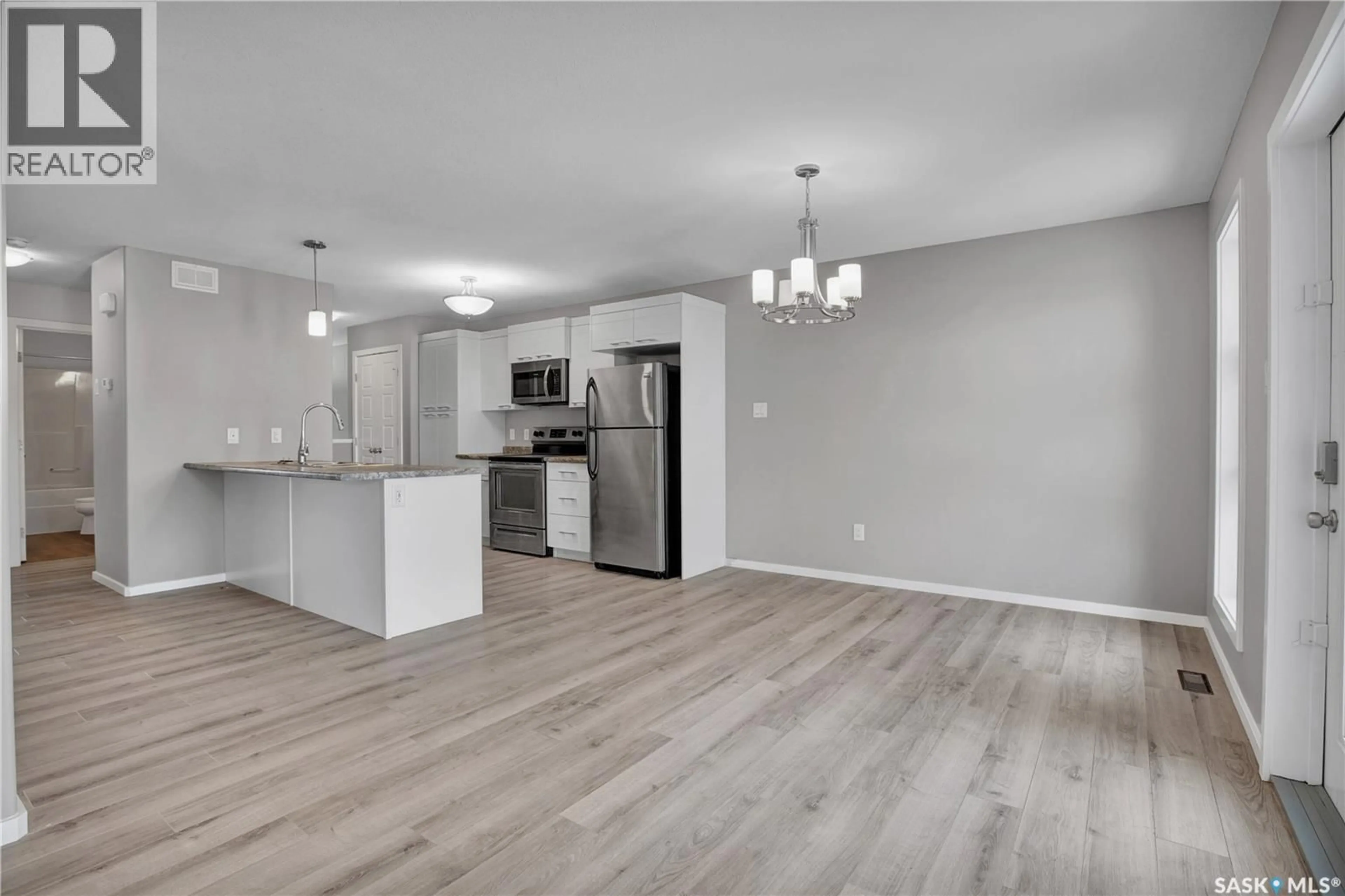 Open concept kitchen, wood/laminate floor for 104 REDDEKOPP CRESCENT, Warman Saskatchewan S0K4S3