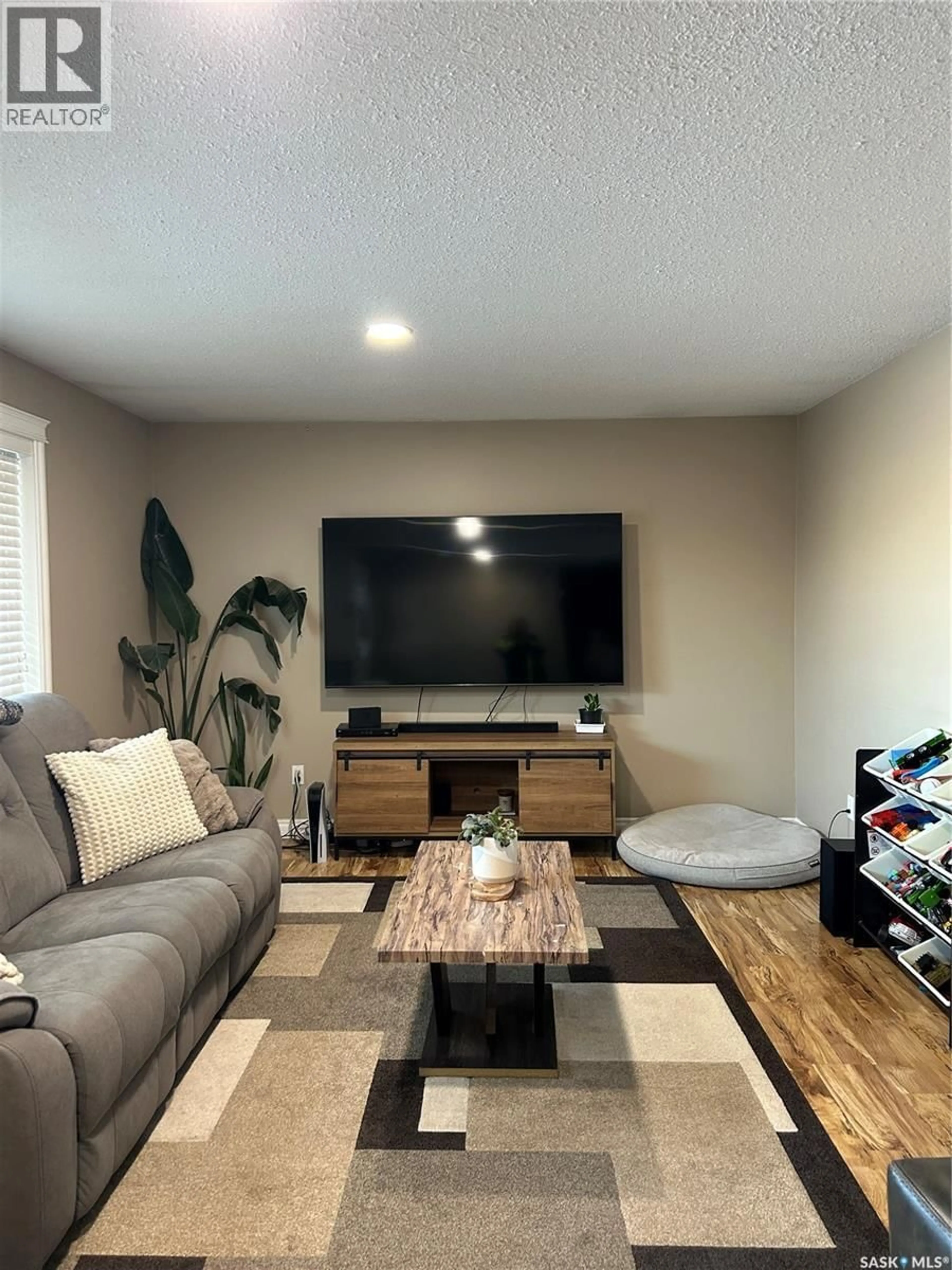 Living room with furniture, wood/laminate floor for 816 8TH AVENUE, Rosthern Saskatchewan S0K3R0