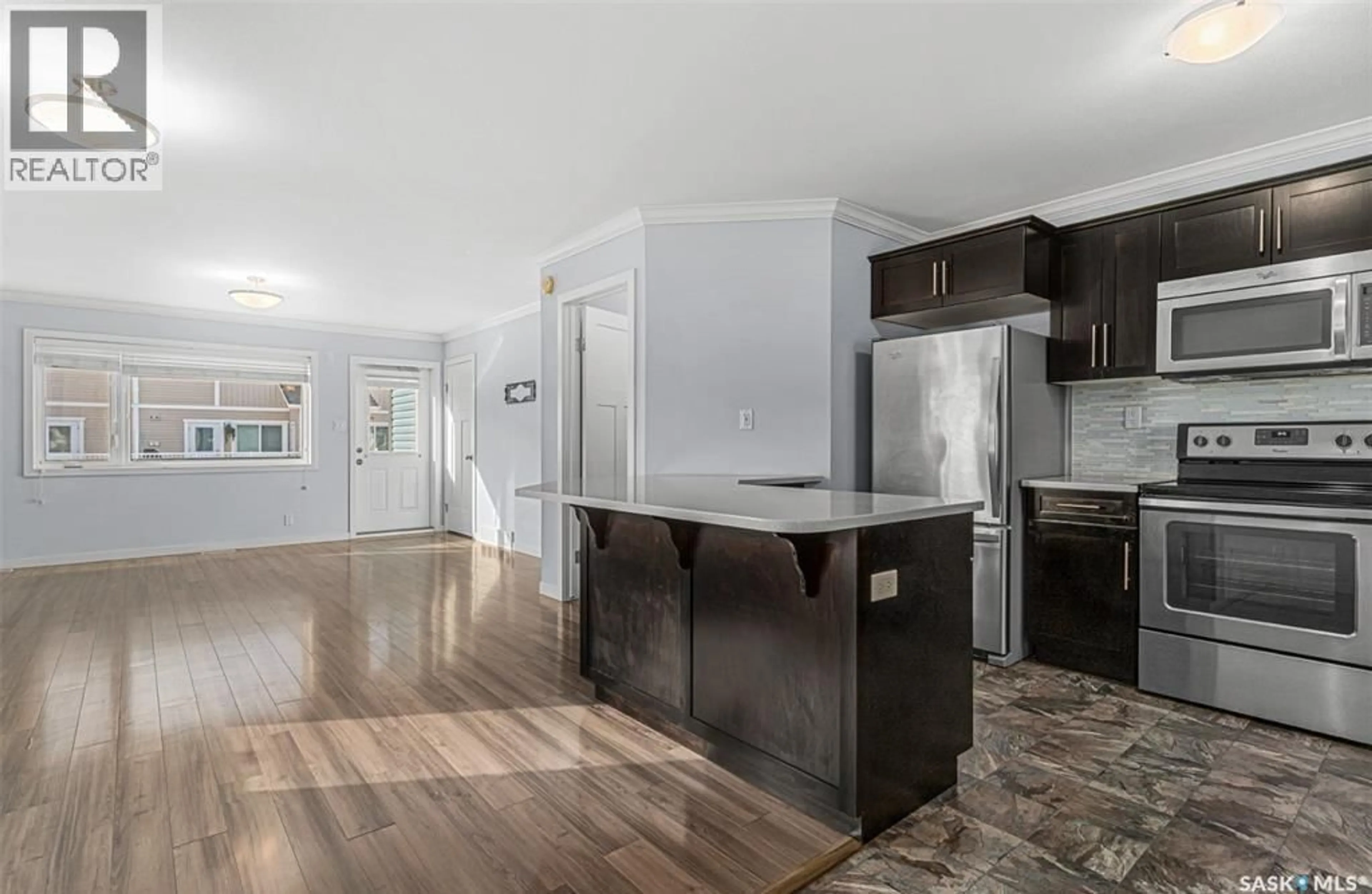 Open concept kitchen, wood/laminate floor for 130 - 1106 MARLATTE CRESCENT, Saskatoon Saskatchewan S7W0W1