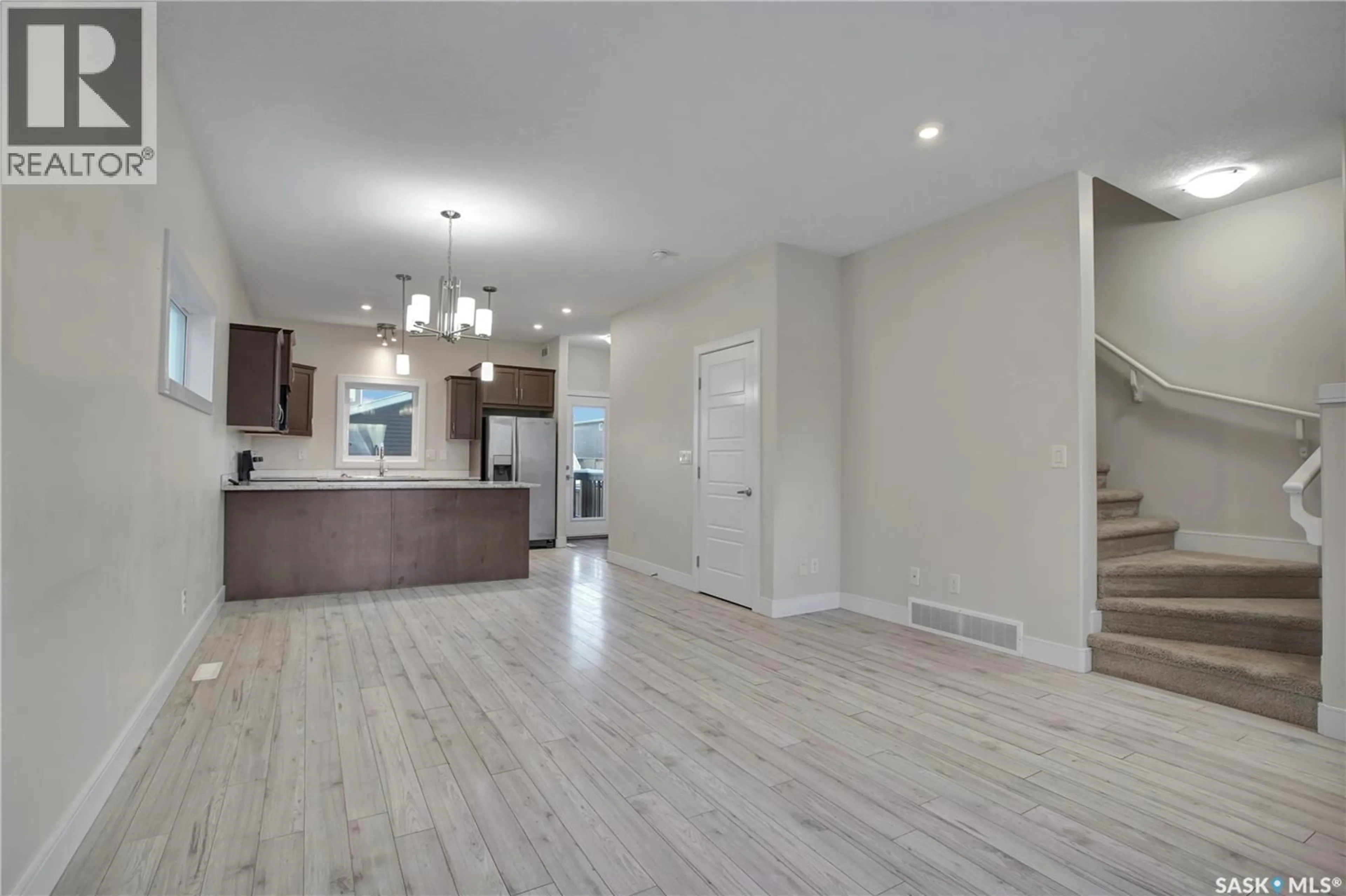 Open concept kitchen, wood/laminate floor for 1069 PARR HILL DRIVE, Martensville Saskatchewan S0K2T1