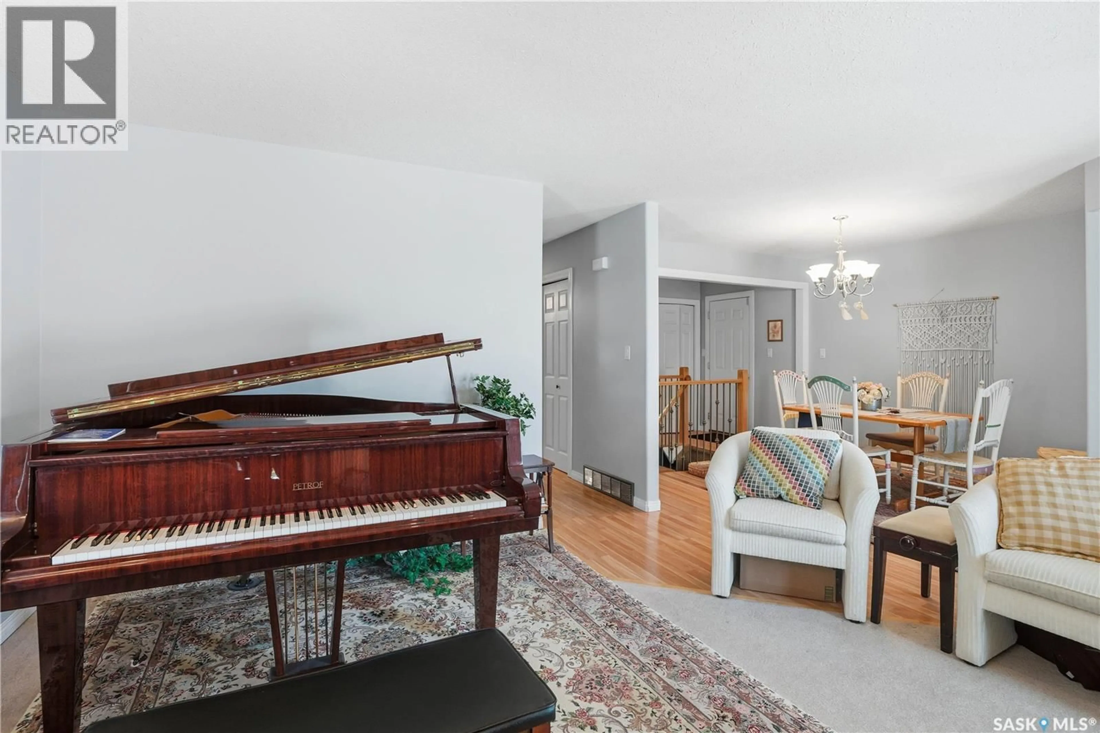 Living room with furniture, wood/laminate floor for 223 DELARONDE LANE, Saskatoon Saskatchewan S7J3Z1