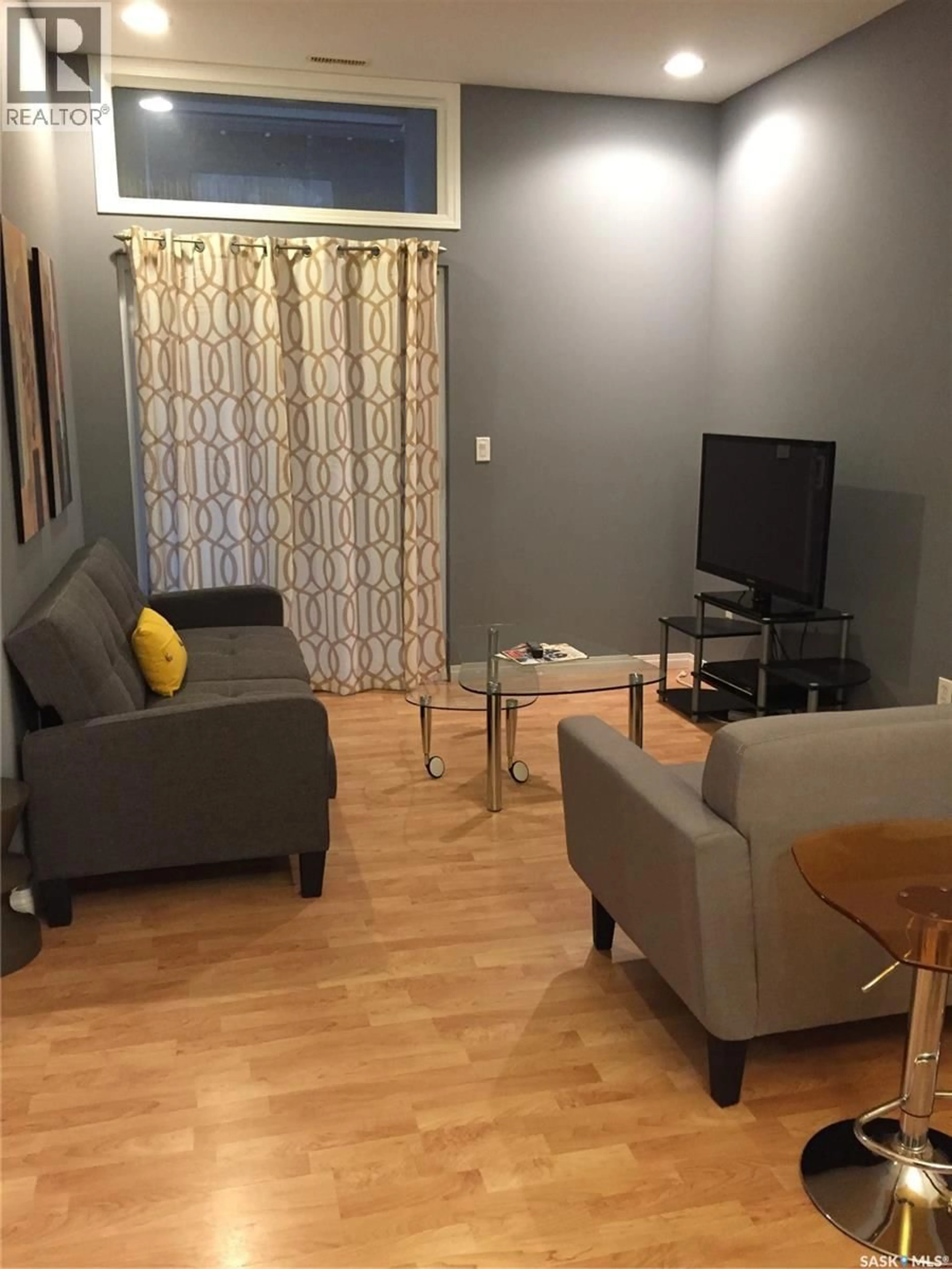 Living room with furniture, wood/laminate floor for 208 - 1901 VICTORIA AVENUE, Regina Saskatchewan S4P3R4