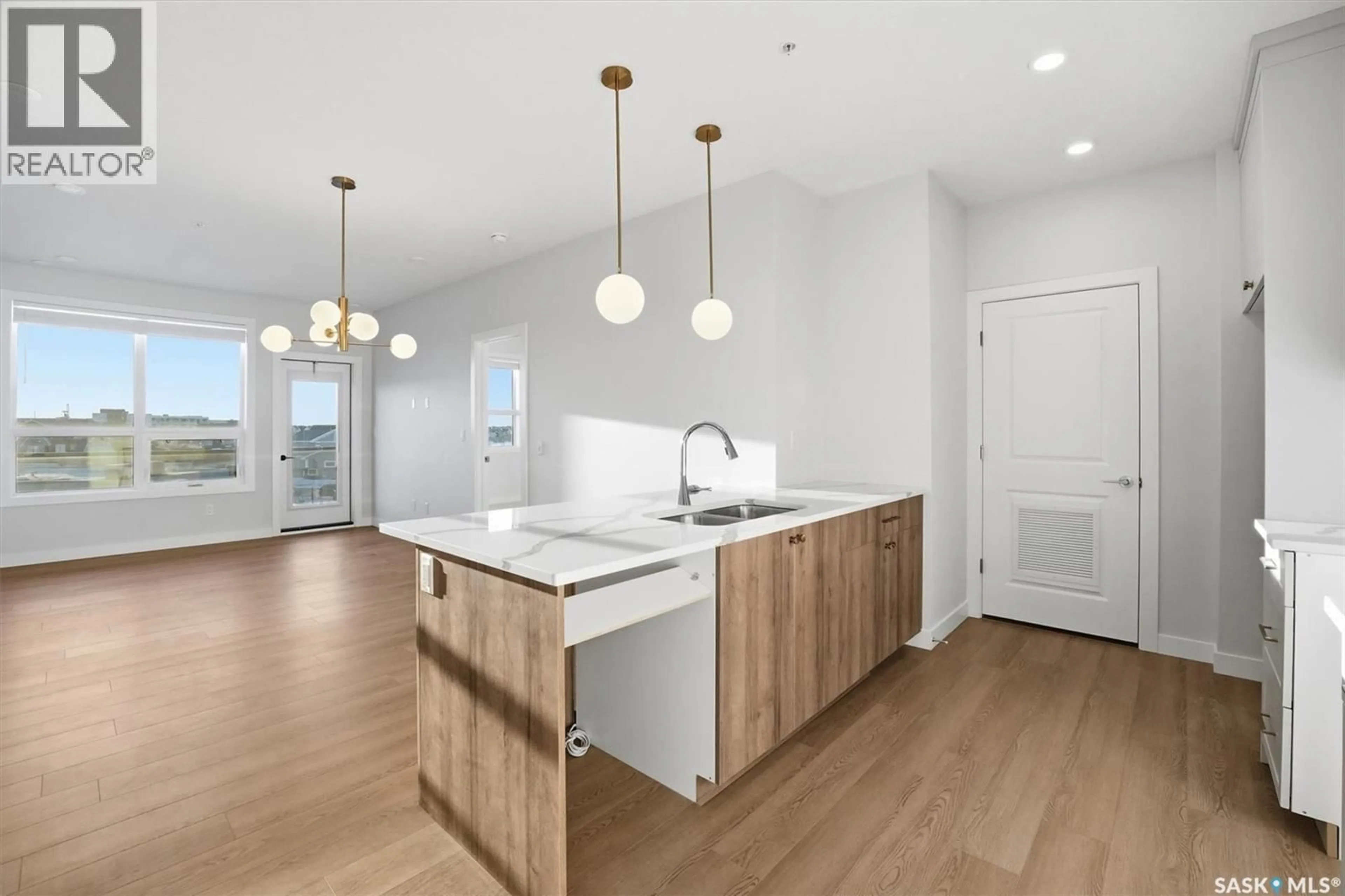 Open concept kitchen, wood/laminate floor for 101 - 1303 SECORD WAY, Saskatoon Saskatchewan S7V1W6