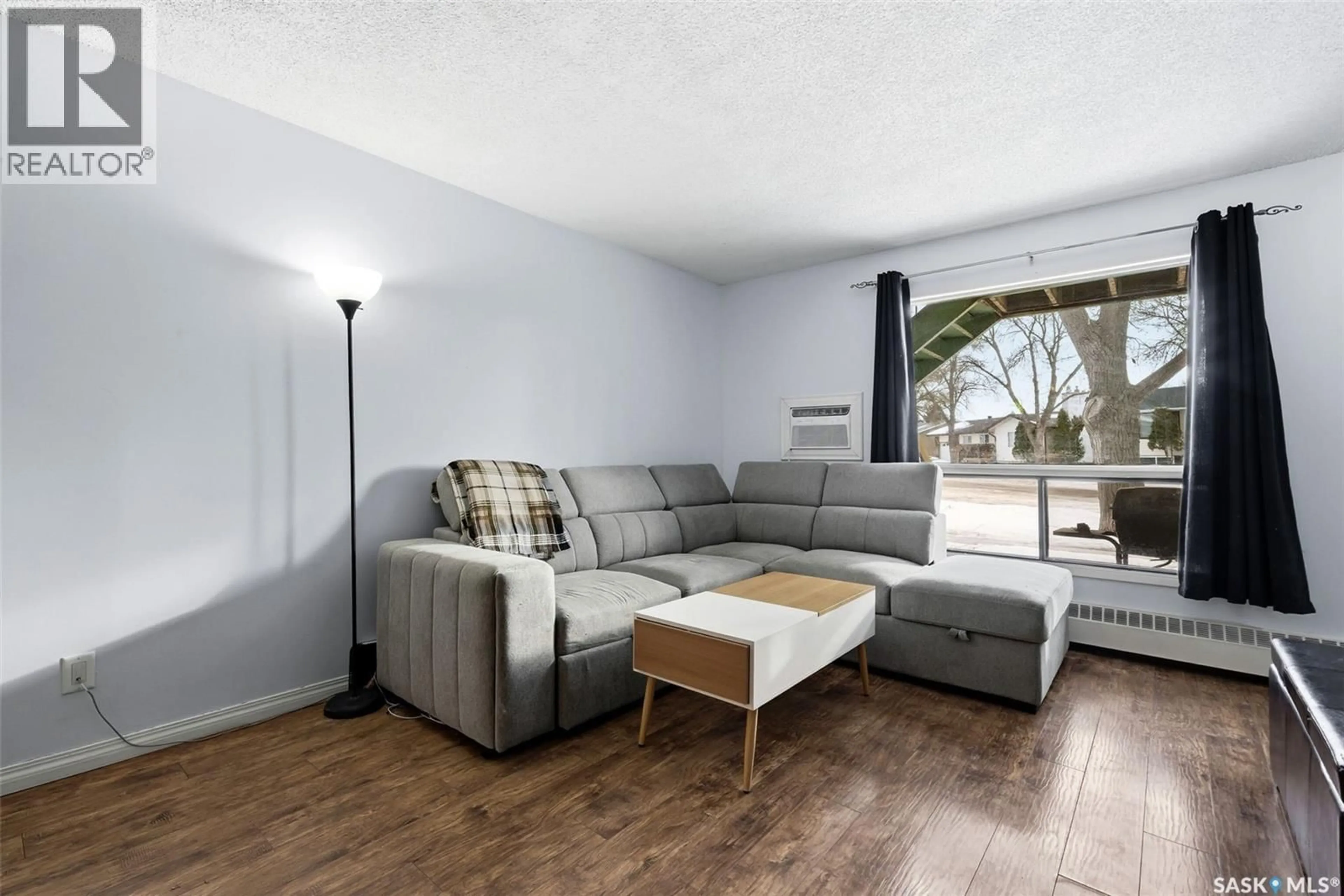 Living room with furniture, wood/laminate floor for 64 NOLLET AVENUE, Regina Saskatchewan S4T7P9