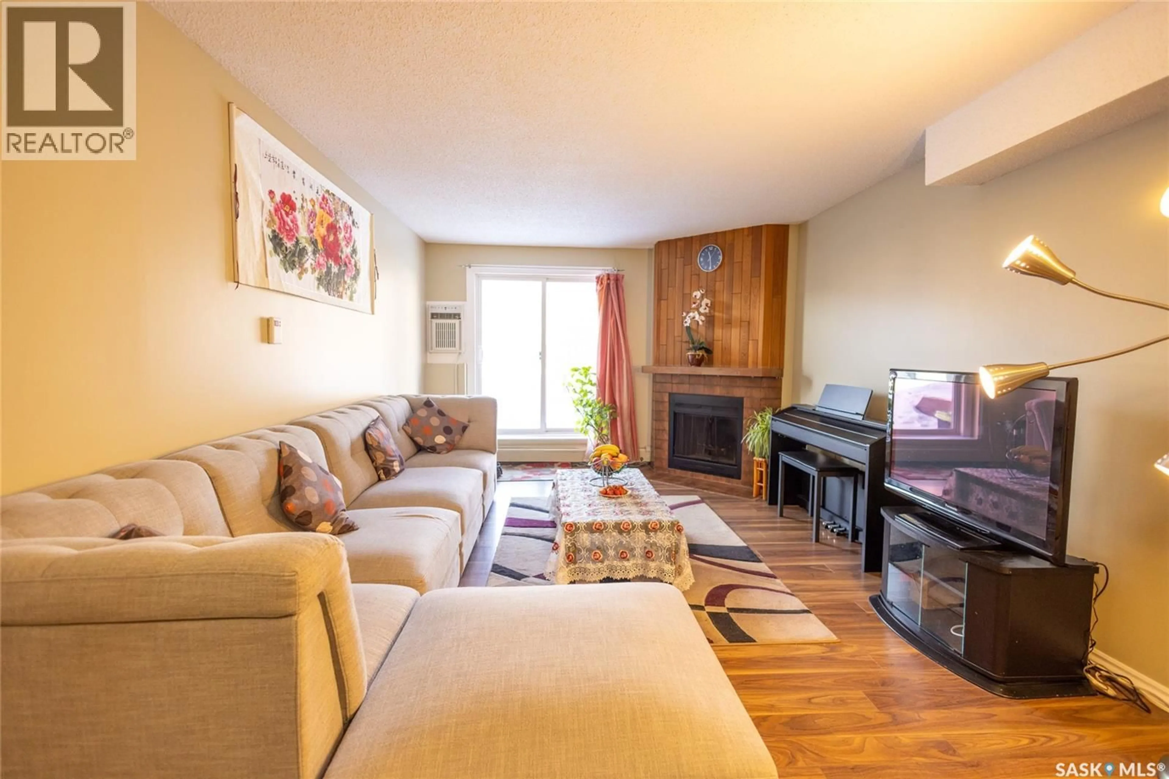Living room with furniture, wood/laminate floor for 105 - 411 TAIT COURT, Saskatoon Saskatchewan S7H5L3