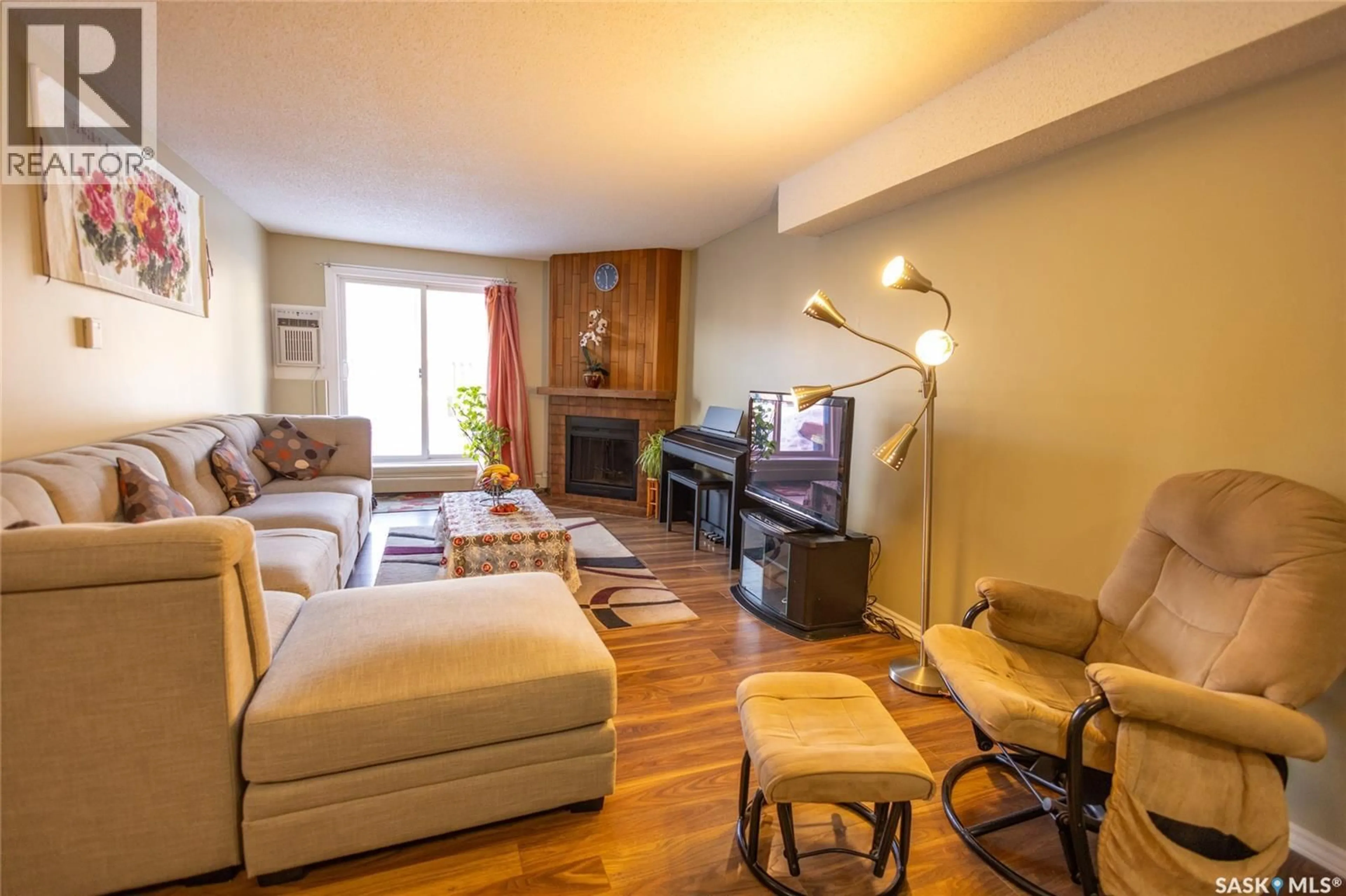 Living room with furniture, wood/laminate floor for 105 - 411 TAIT COURT, Saskatoon Saskatchewan S7H5L3