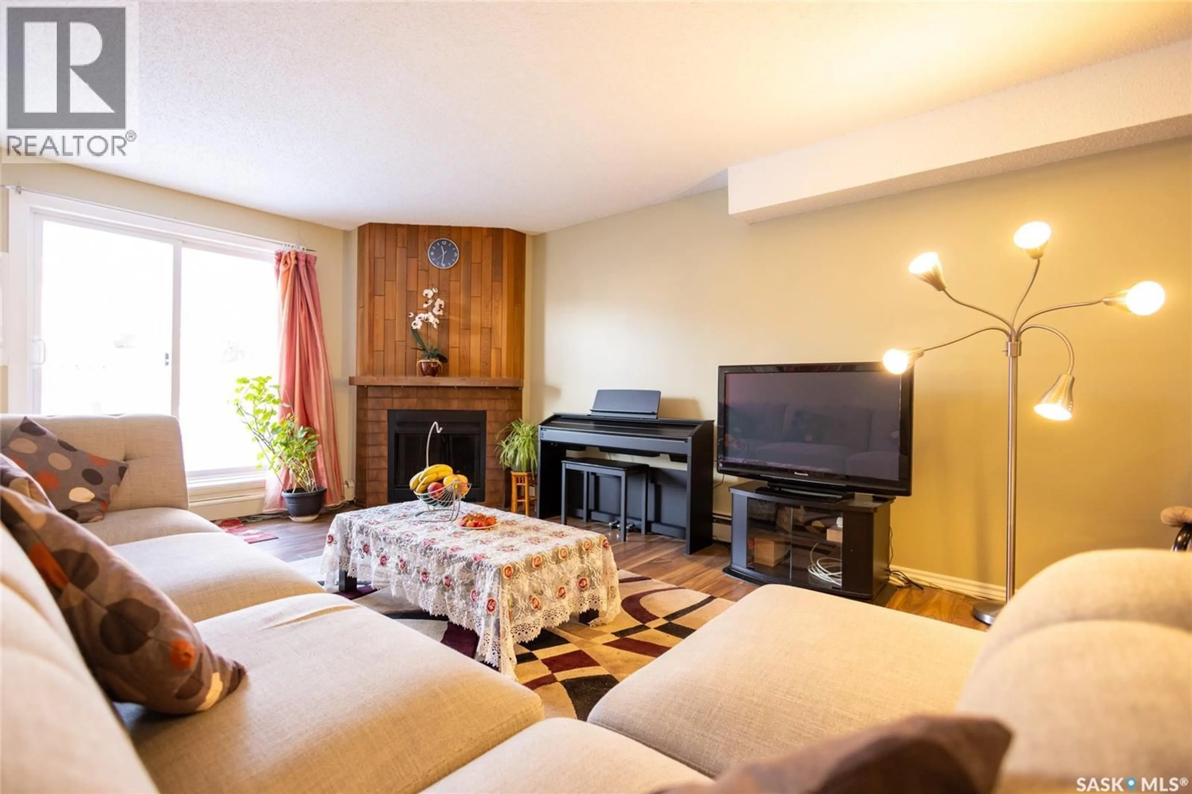 Living room with furniture, wood/laminate floor for 105 - 411 TAIT COURT, Saskatoon Saskatchewan S7H5L3