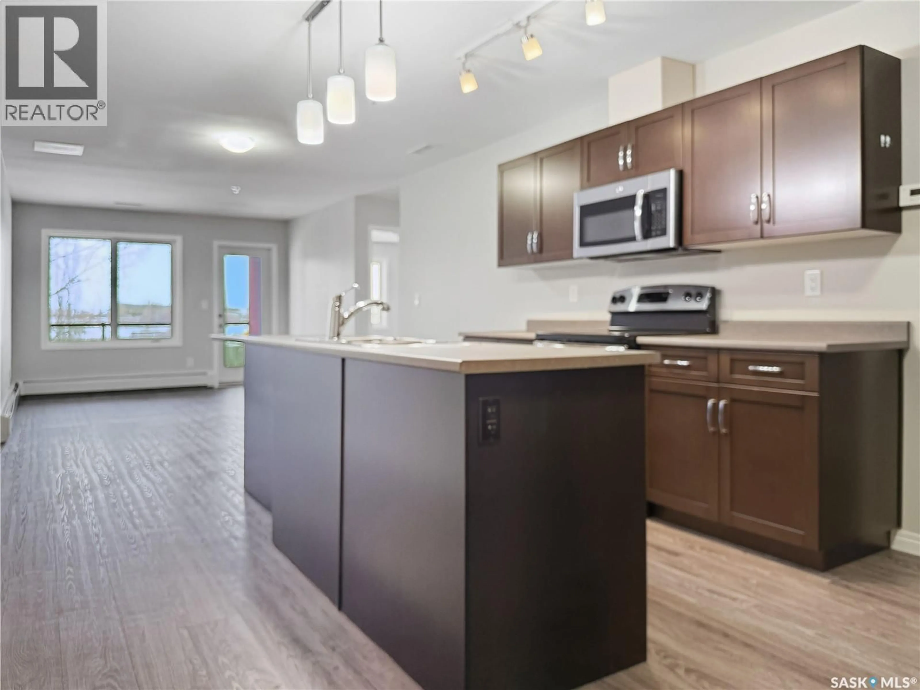 Open concept kitchen, wood/laminate floor for 309 - 2452 KILLDEER DRIVE, North Battleford Saskatchewan S9A3T5