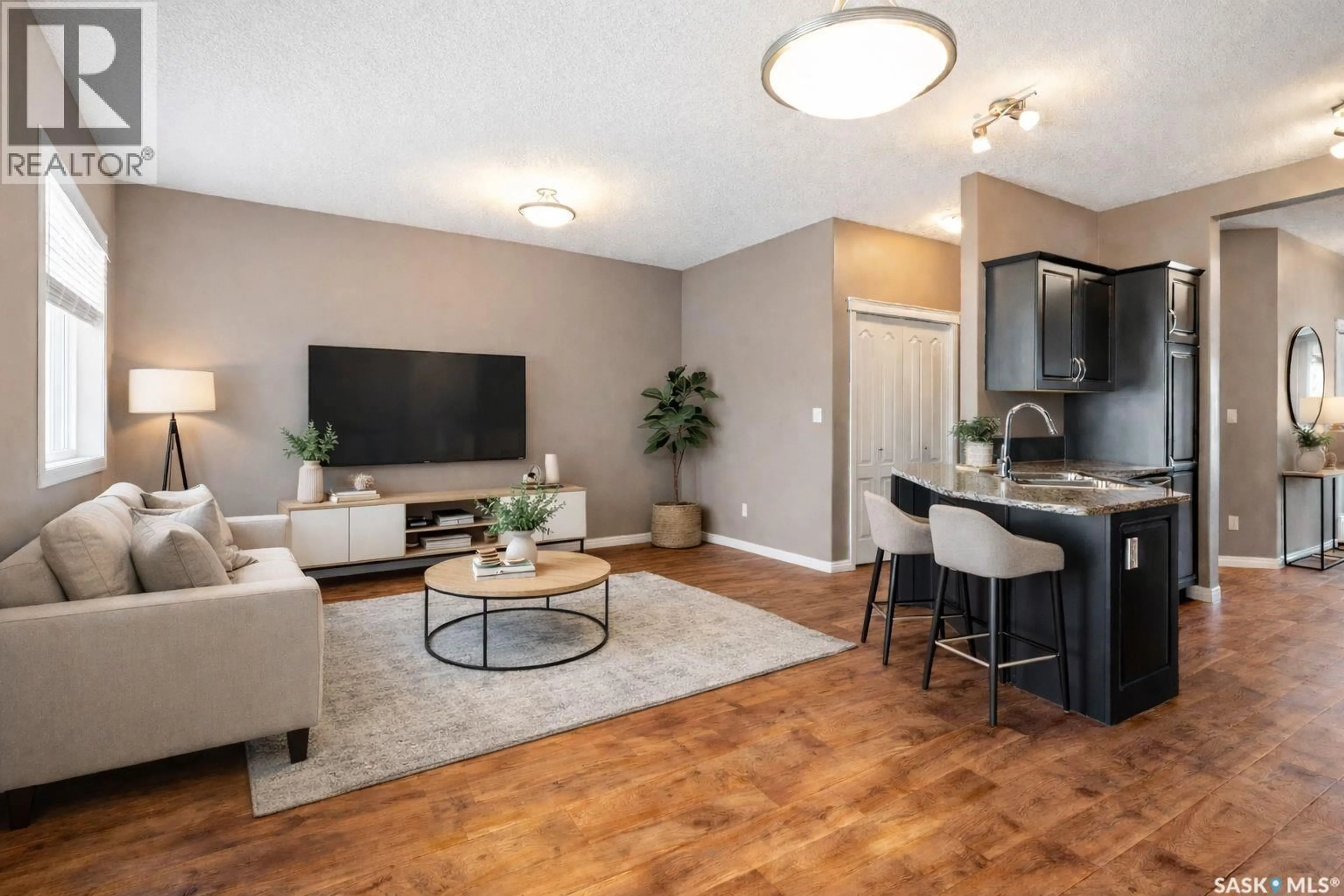 Living room with furniture, wood/laminate floor for 3830 - 507 DEWDNEY AVENUE, Regina Saskatchewan S4Z0A6