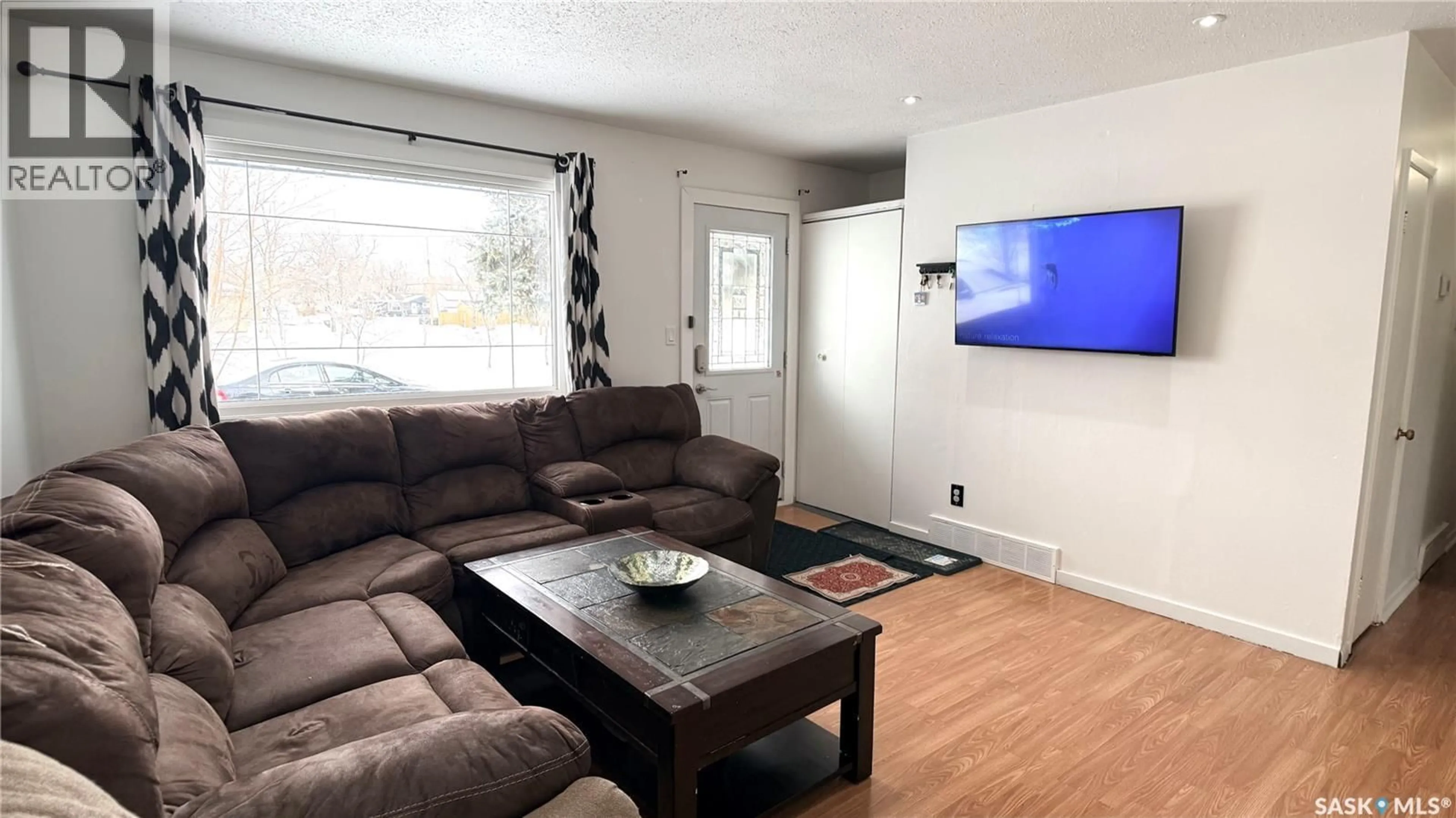 Living room with furniture, wood/laminate floor for 1413 NICHOLSON ROAD, Estevan Saskatchewan S4A1T6