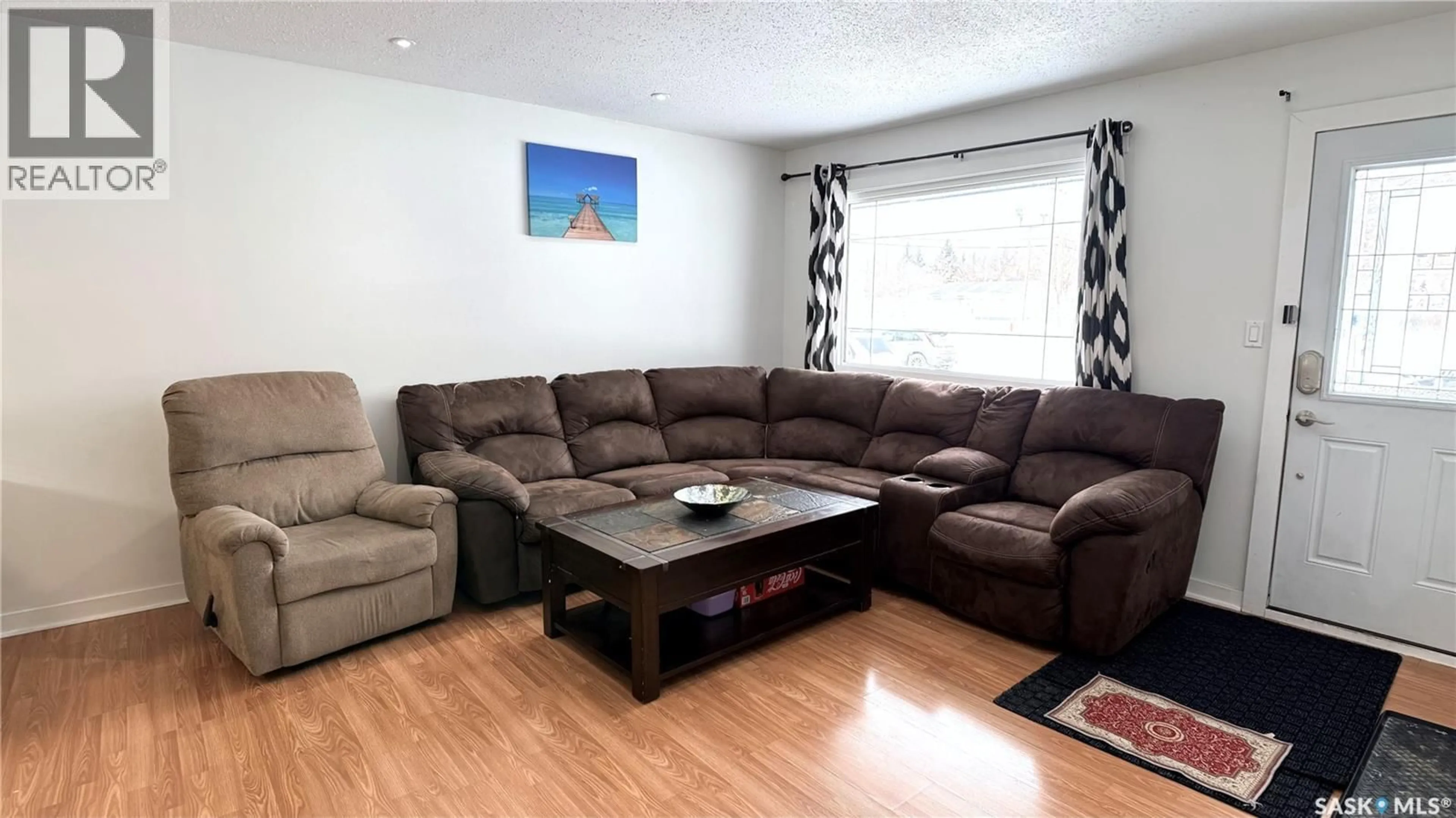 Living room with furniture, wood/laminate floor for 1413 NICHOLSON ROAD, Estevan Saskatchewan S4A1T6