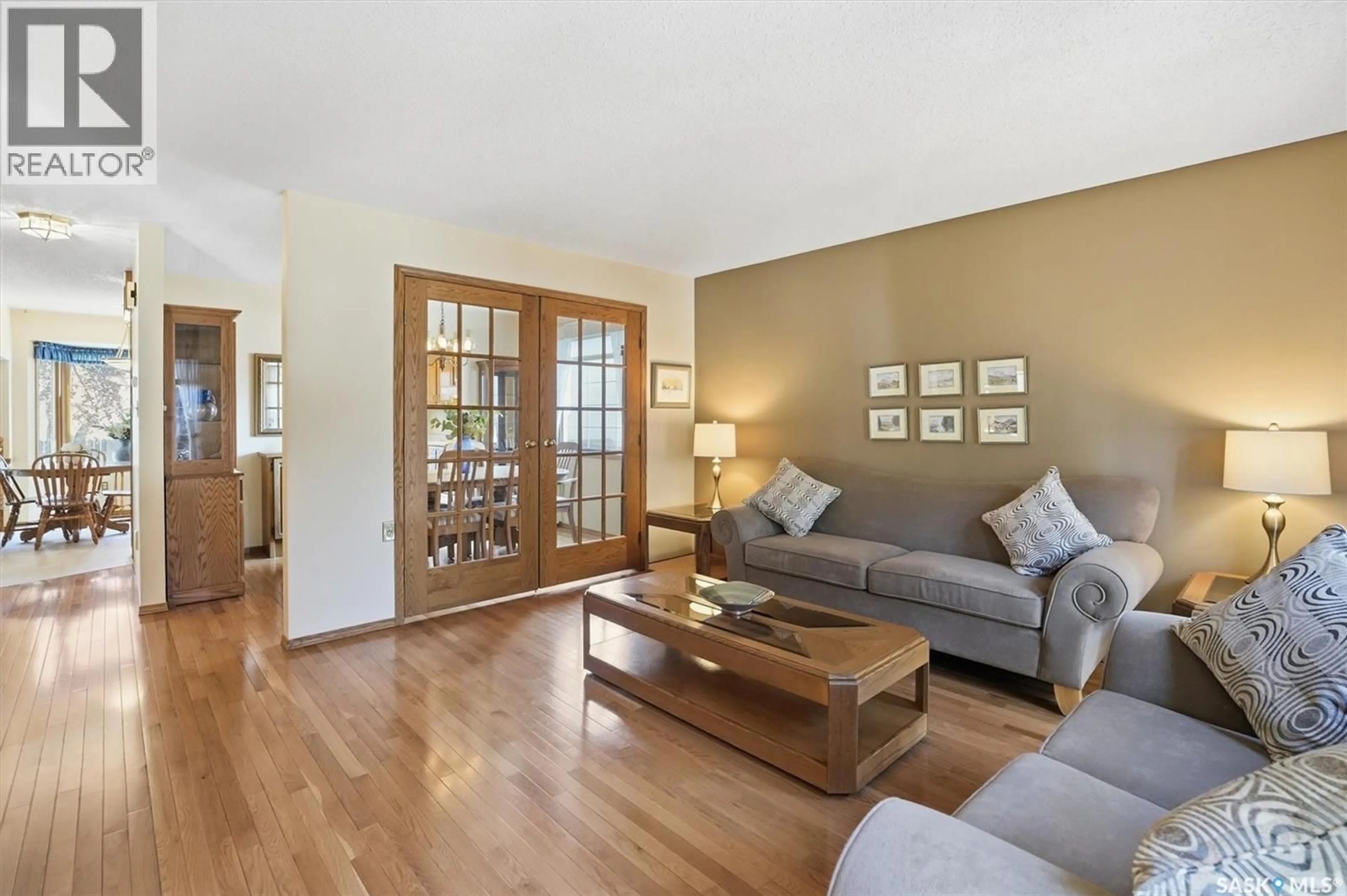 Living room with furniture, wood/laminate floor for 458 CHARLEBOIS TERRACE, Saskatoon Saskatchewan S7K5K1