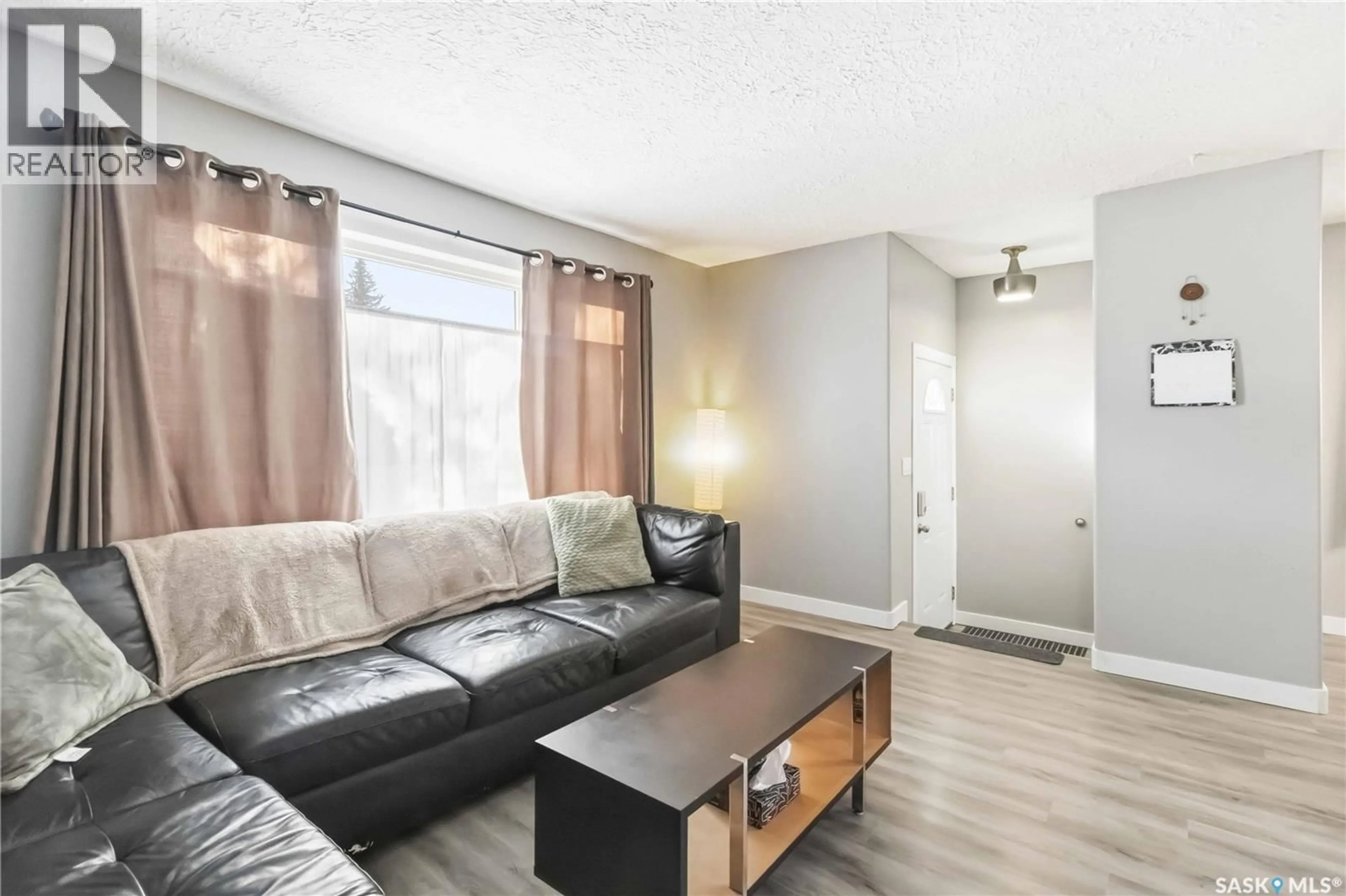 Living room with furniture, wood/laminate floor for 732 MCCORMACK ROAD, Saskatoon Saskatchewan S7M4Z9