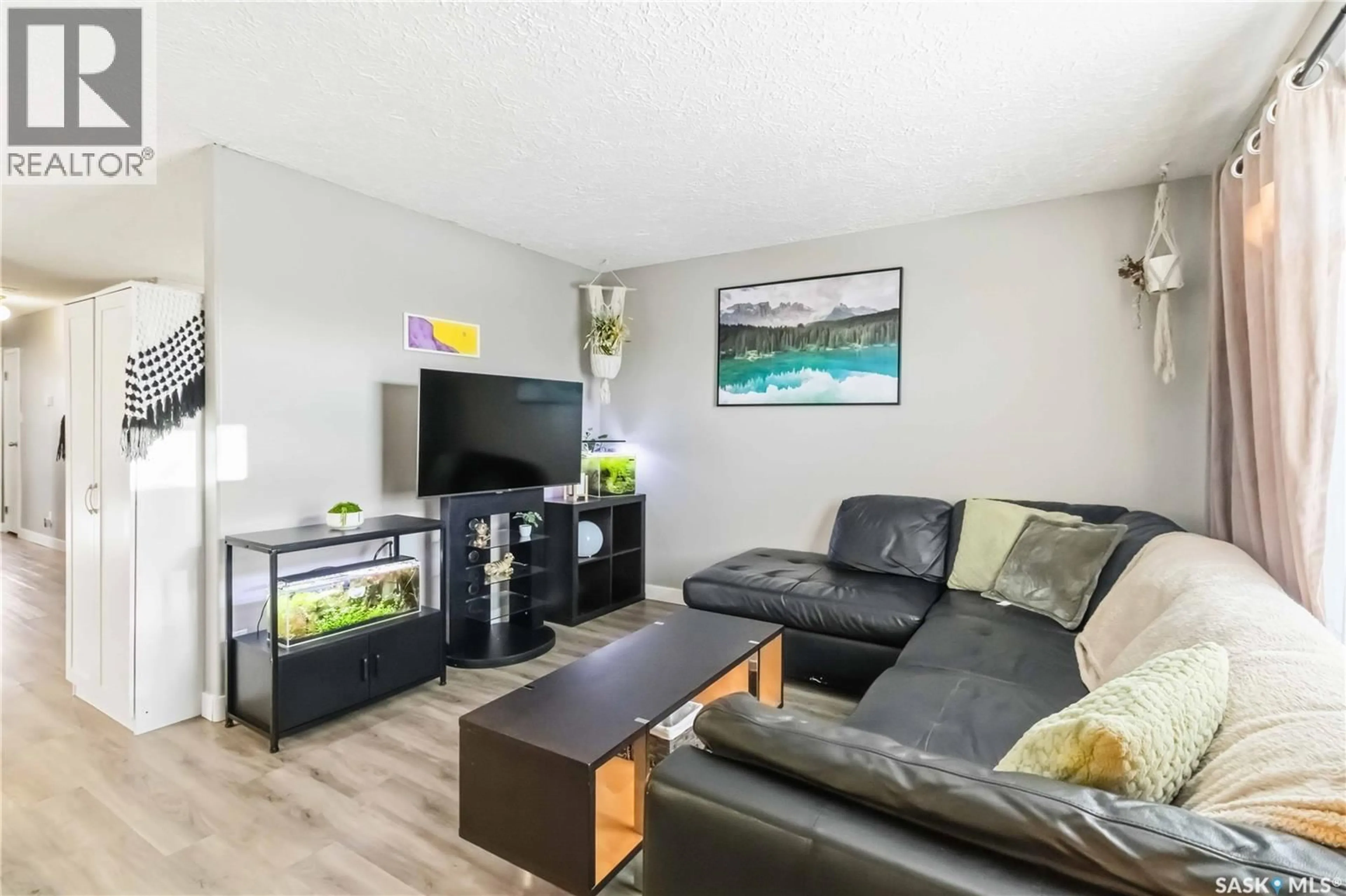 Living room with furniture, wood/laminate floor for 732 MCCORMACK ROAD, Saskatoon Saskatchewan S7M4Z9