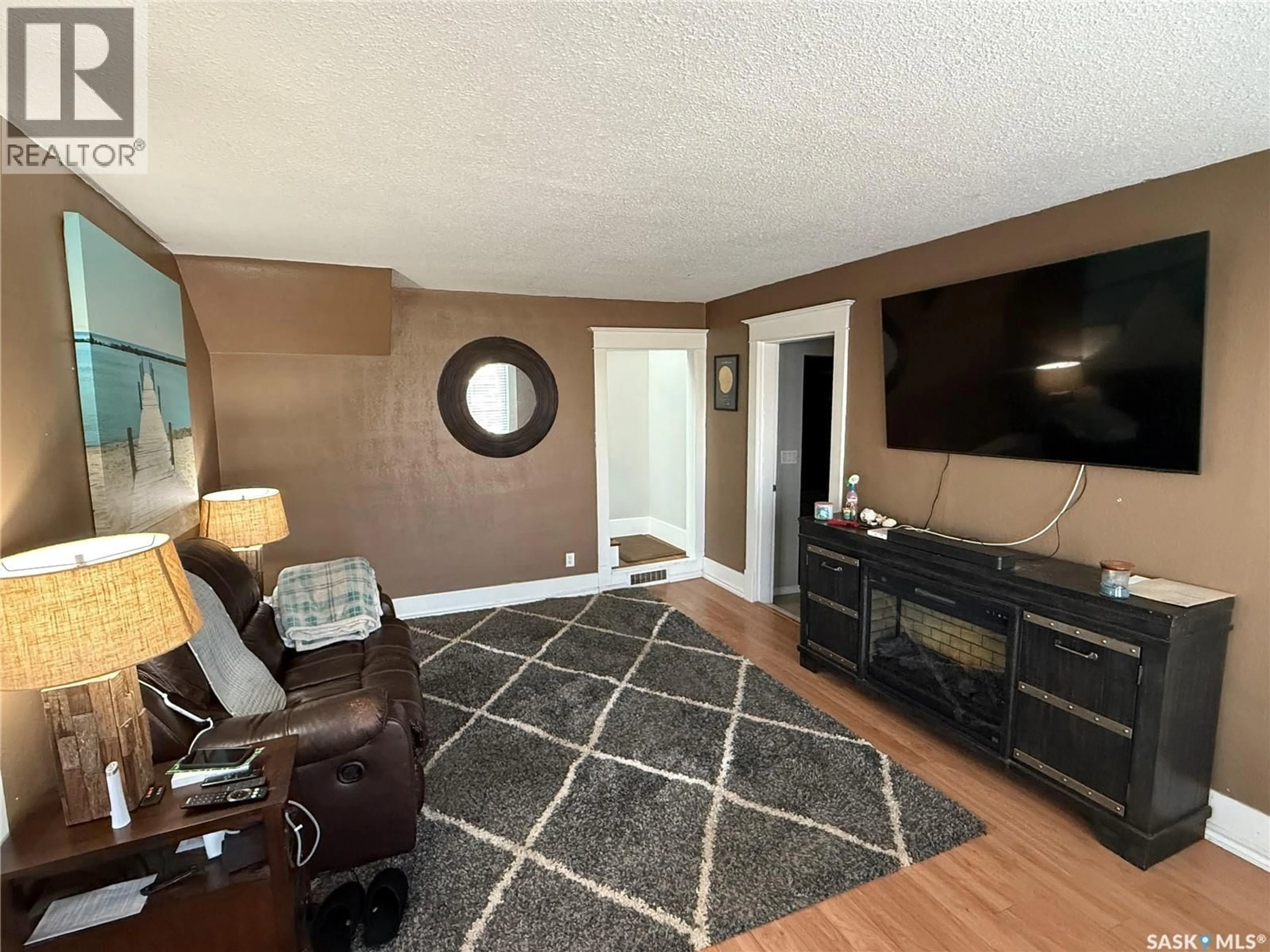 Living room with furniture, wood/laminate floor for 711 LUTEN AVENUE, Radville Saskatchewan S0C2G0