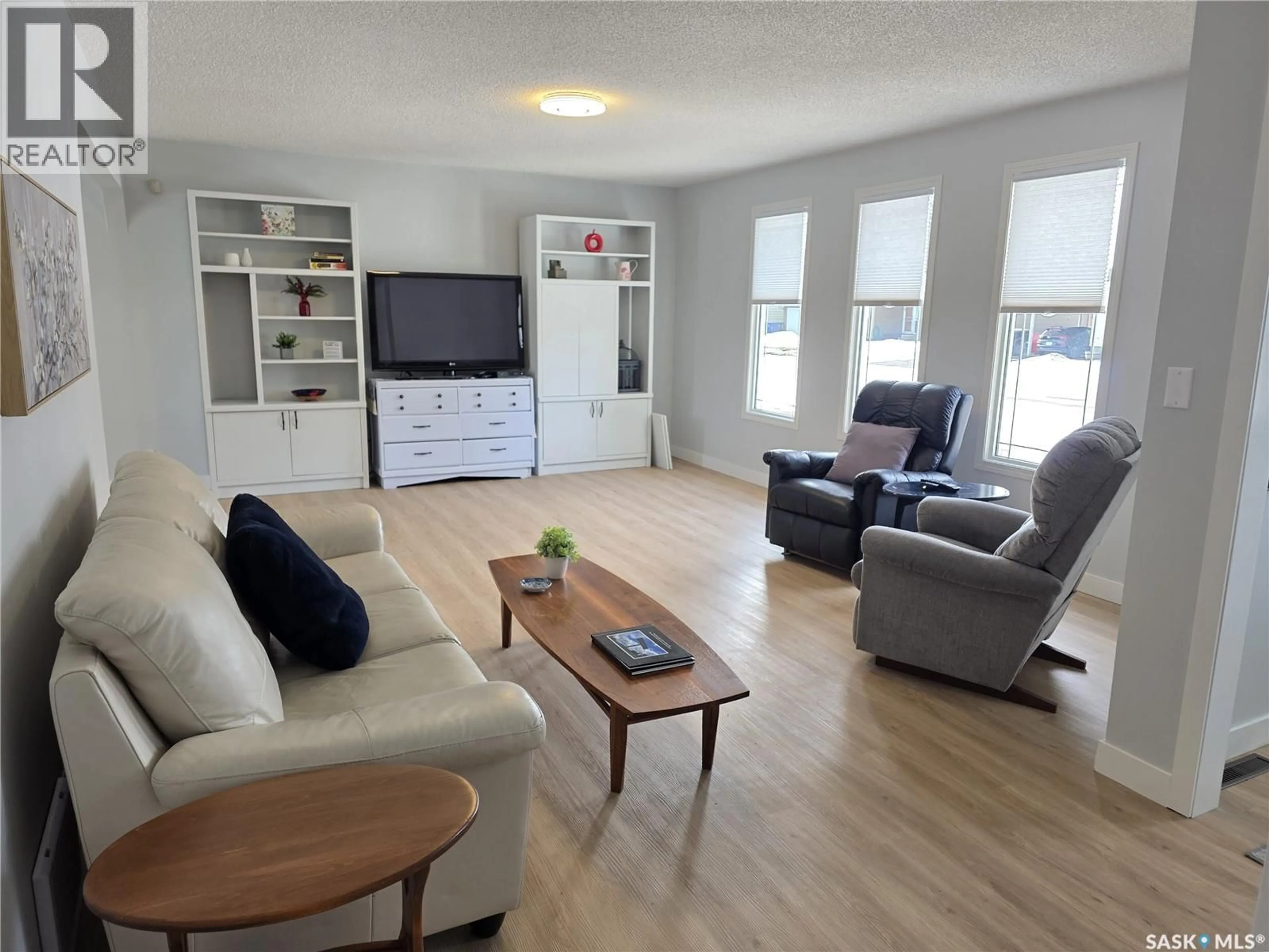 Living room with furniture, wood/laminate floor for 403 THOMSON STREET, Outlook Saskatchewan S0L2N0