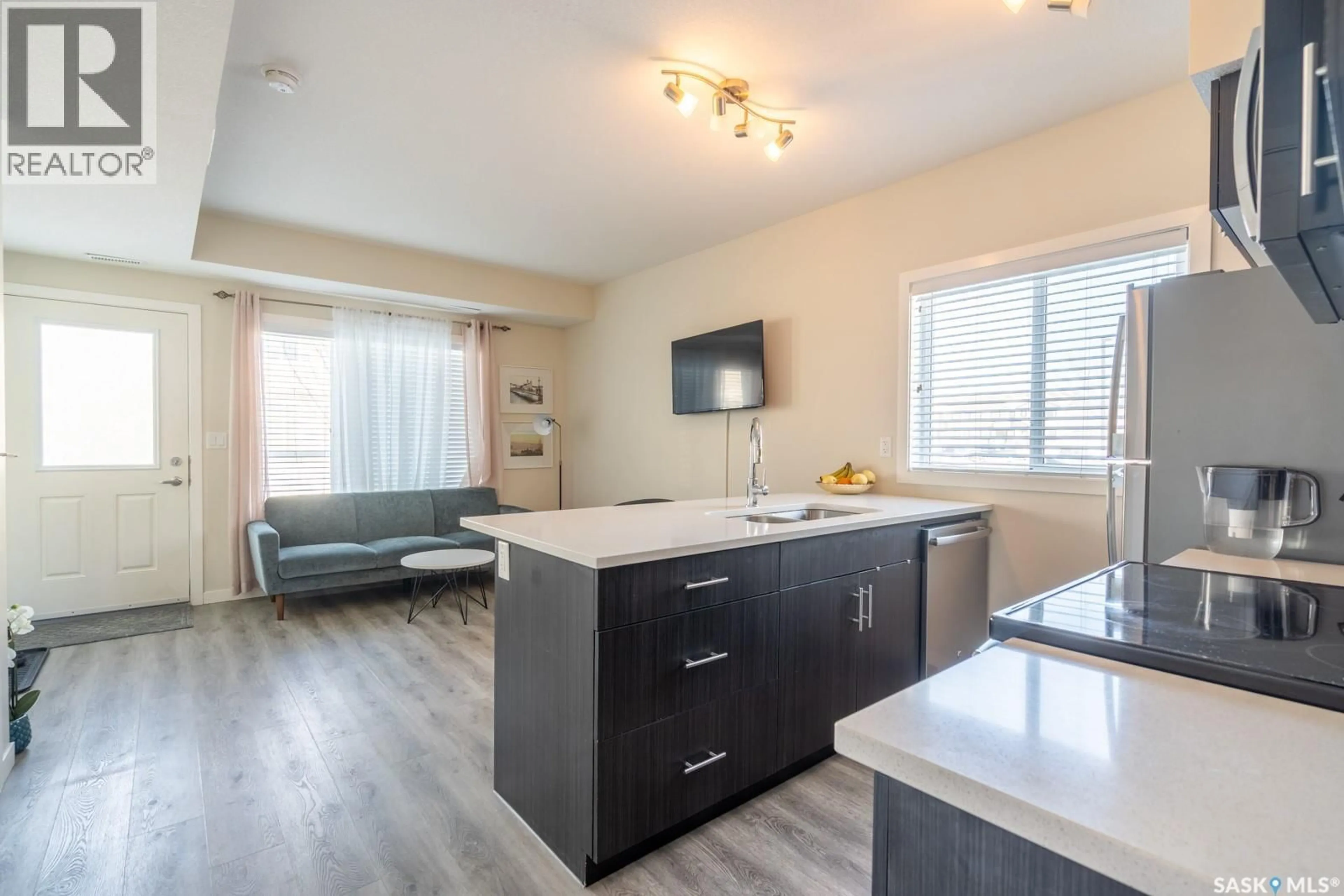 Open concept kitchen, wood/laminate floor for 203A - 3351 GREEN POPPY STREET, Regina Saskatchewan S4V3P6