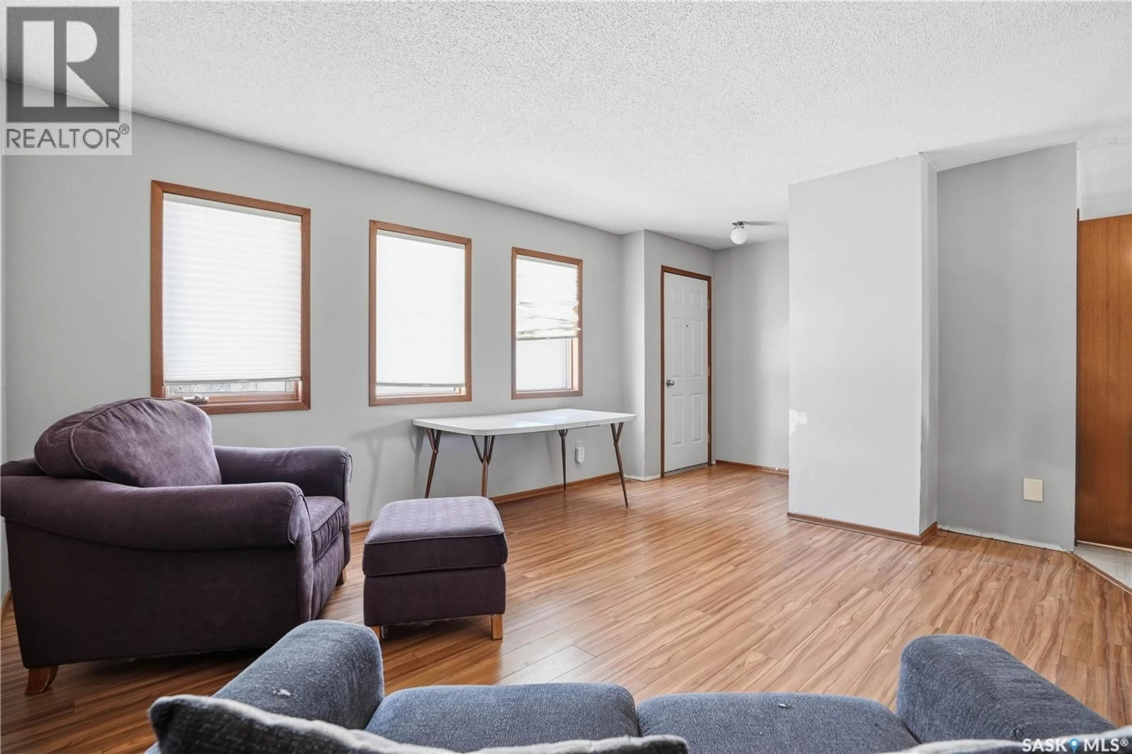 Living room with furniture, wood/laminate floor for 201 BRUNSWICK STREET, Pense Saskatchewan S0G3W0