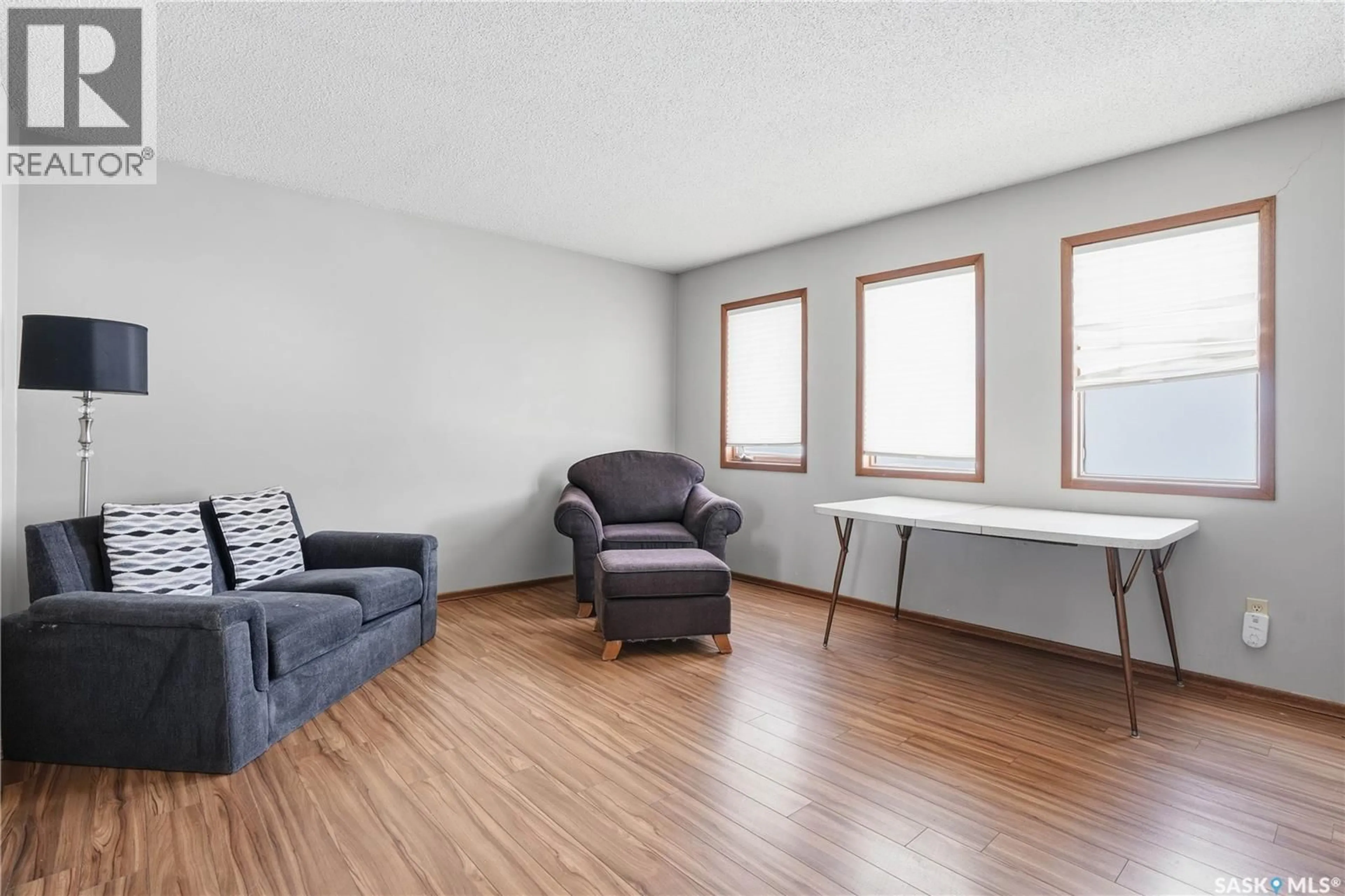 Living room with furniture, wood/laminate floor for 201 BRUNSWICK STREET, Pense Saskatchewan S0G3W0