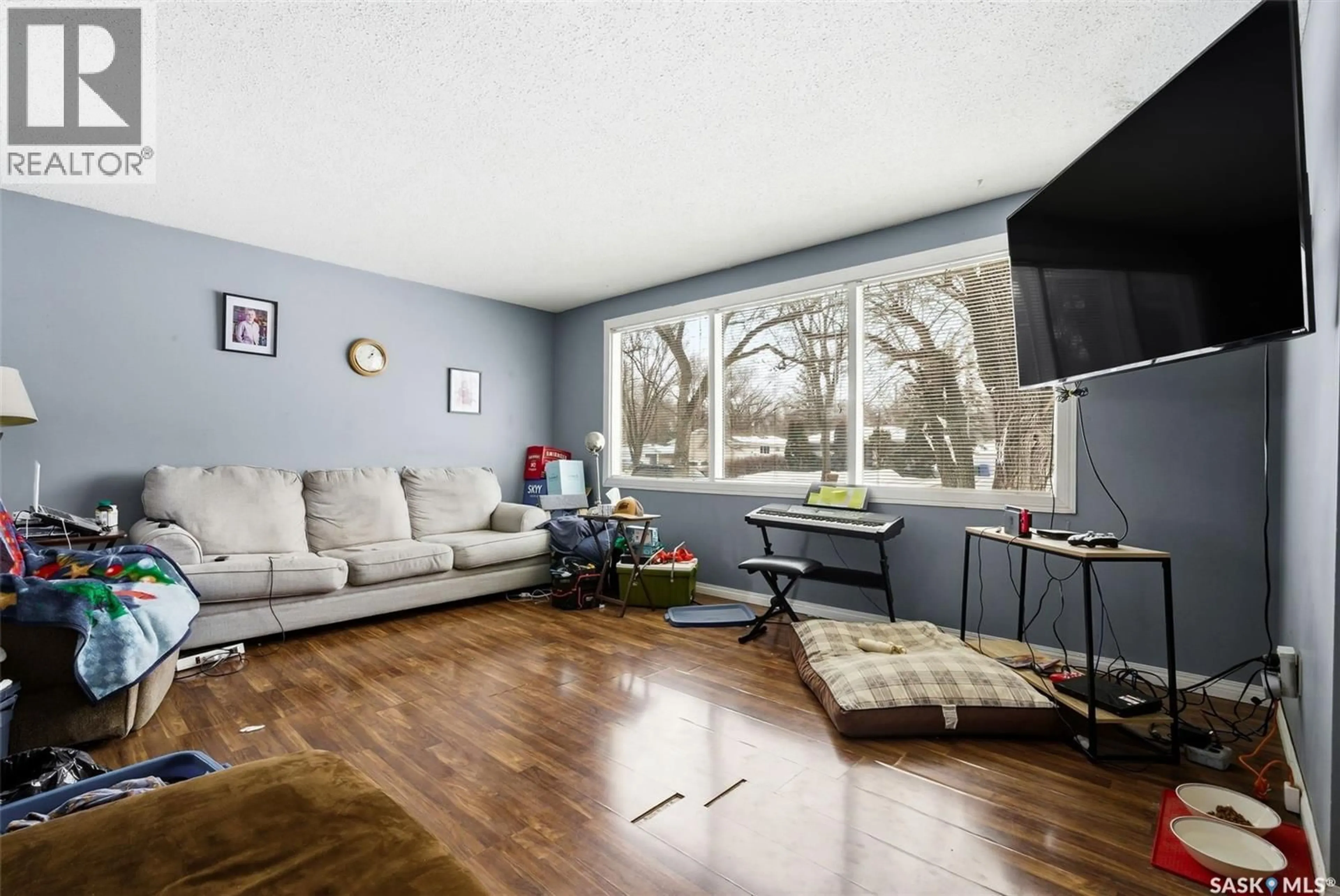Living room with furniture, wood/laminate floor for 2804 GRANT ROAD, Regina Saskatchewan S4S5G2