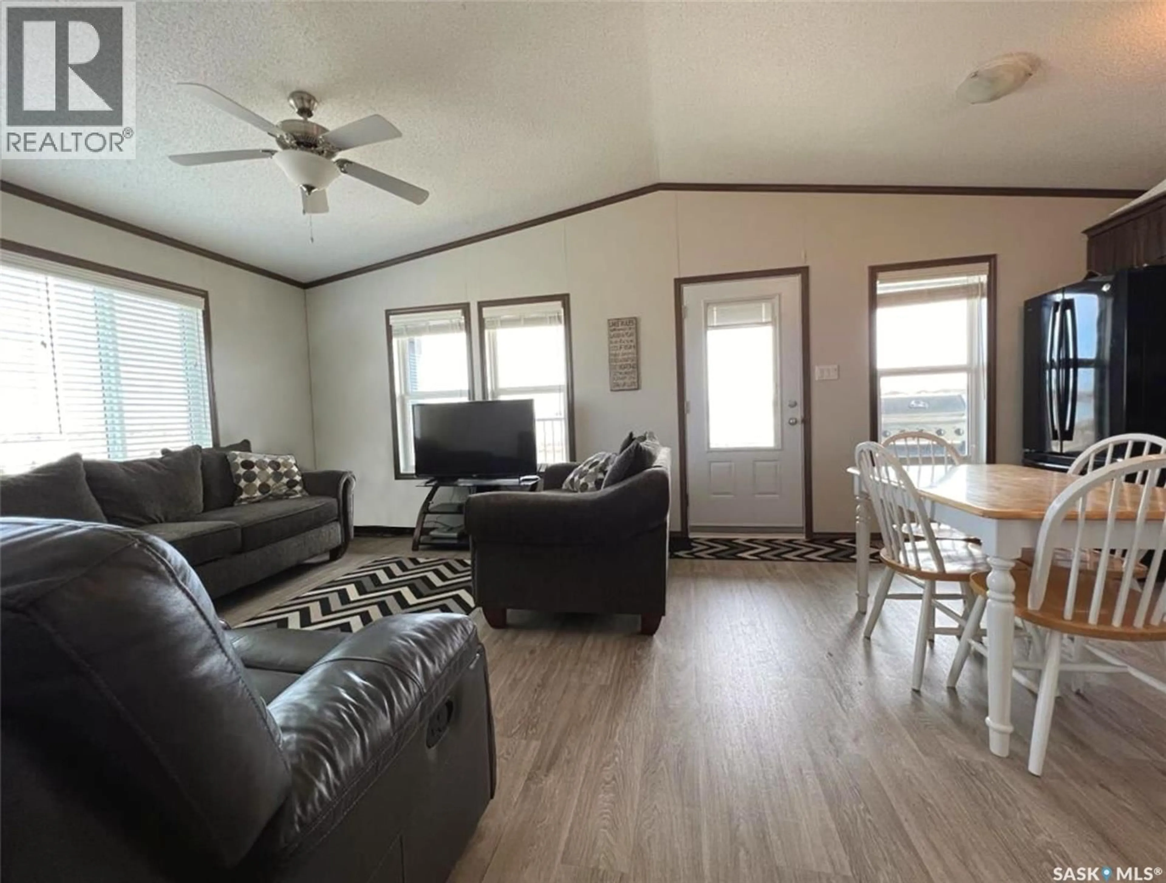 Living room with furniture, wood/laminate floor for 701 PEBBLE DRIVE, Webb Rm No. 138 Saskatchewan S0N2X0